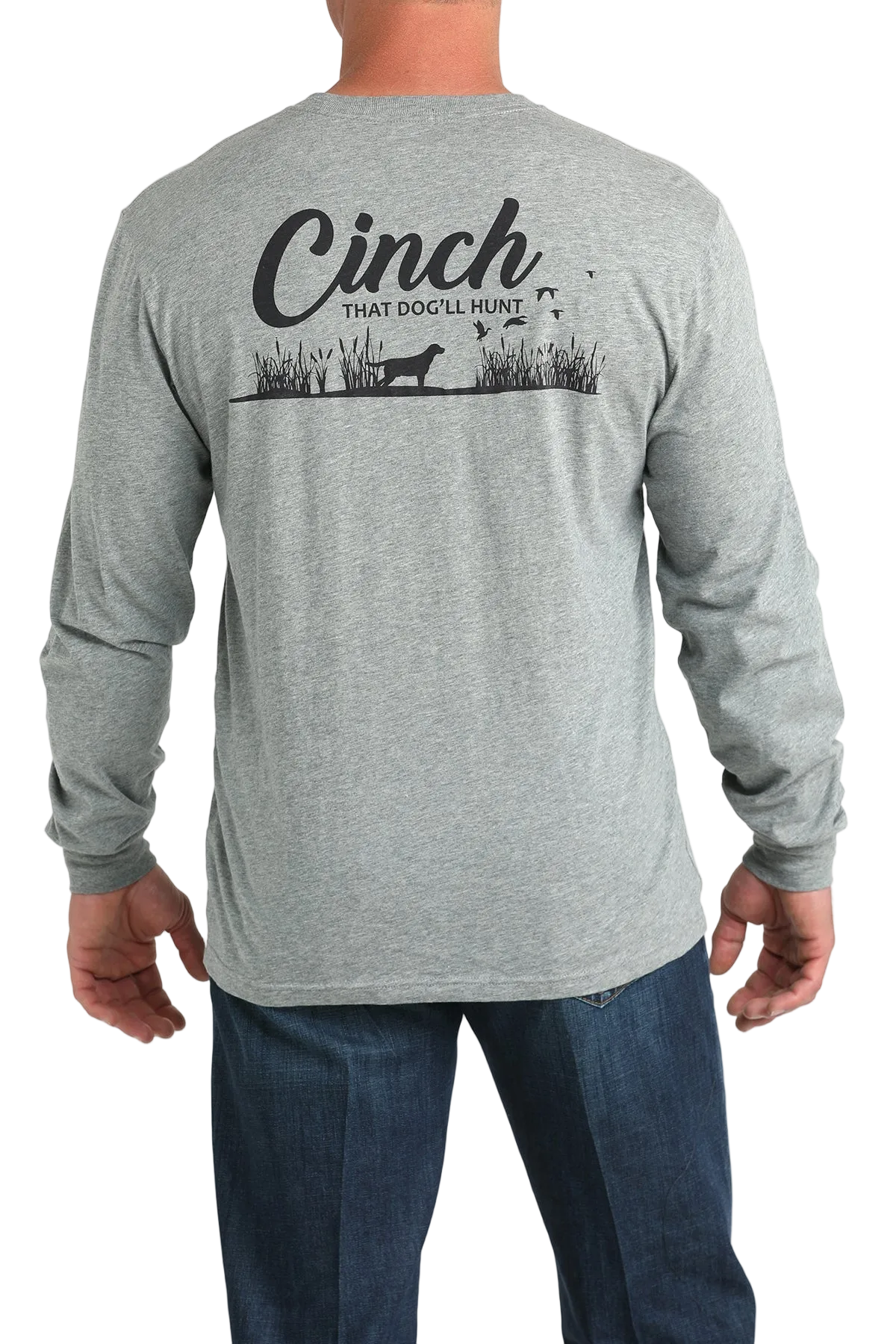 A man wearing a gray long-sleeve shirt and dark jeans is shown from the back. The shirt has a black graphic with the word “Cinch” and a hunting dog design