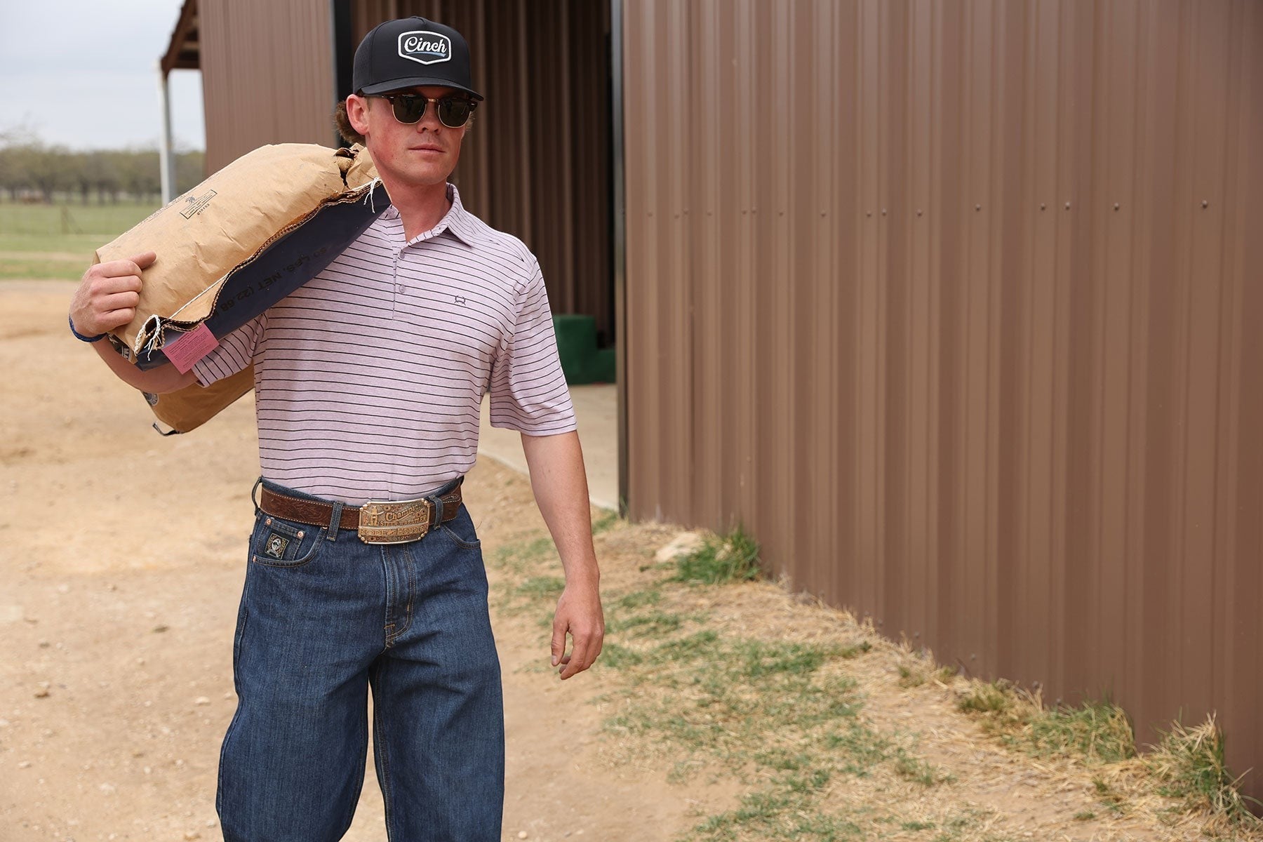 Go West Supply Men's pink and white striped short sleeve ArenaFlex polo shirt with a spread collar and embroidered logo.