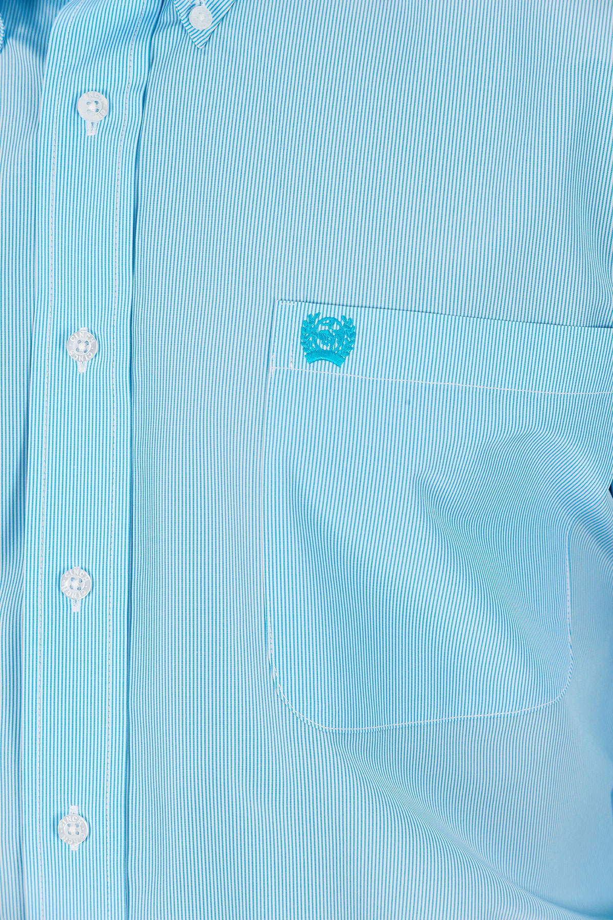 Close-up of a light blue, long sleeve, button-down shirt, with white buttons and a chest pocket 