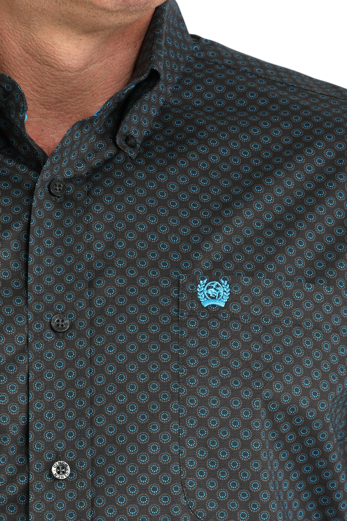 Close-up of a man wearing a patterned black long sleeve button-down shirt on a transparent background 