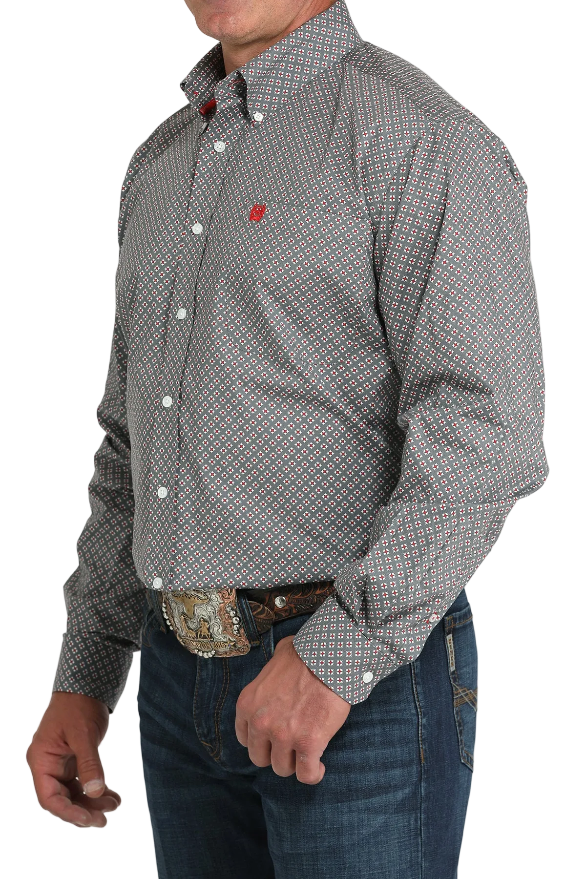 A man wearing a gray patterned button-up shirt, dark jeans, and a large belt buckle stands against a transparent background