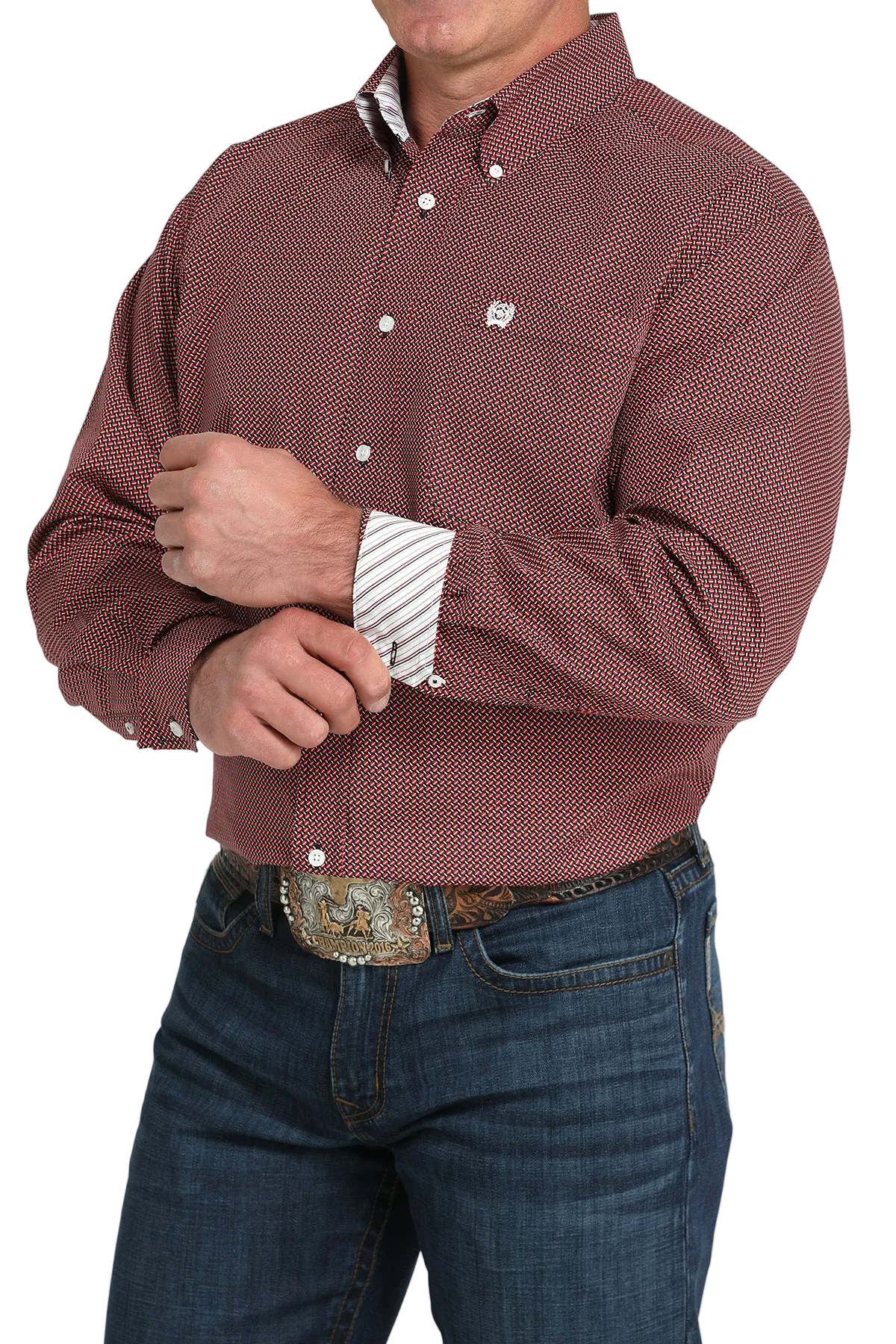 A man wearing a maroon patterned button-up shirt with contrasting cuffs, dark jeans, and a large belt buckle, standing against a transparent background