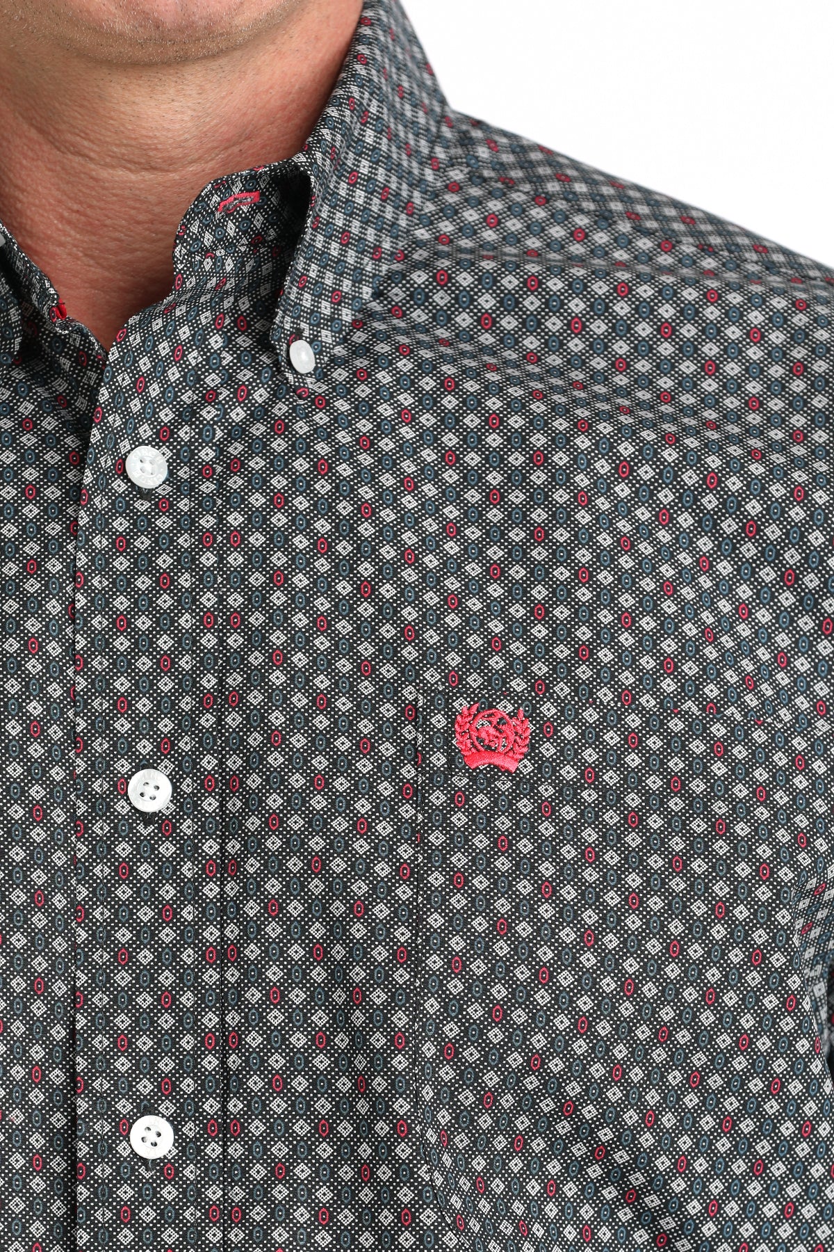 Close-up of a patterned shirt with a small logo on a white background