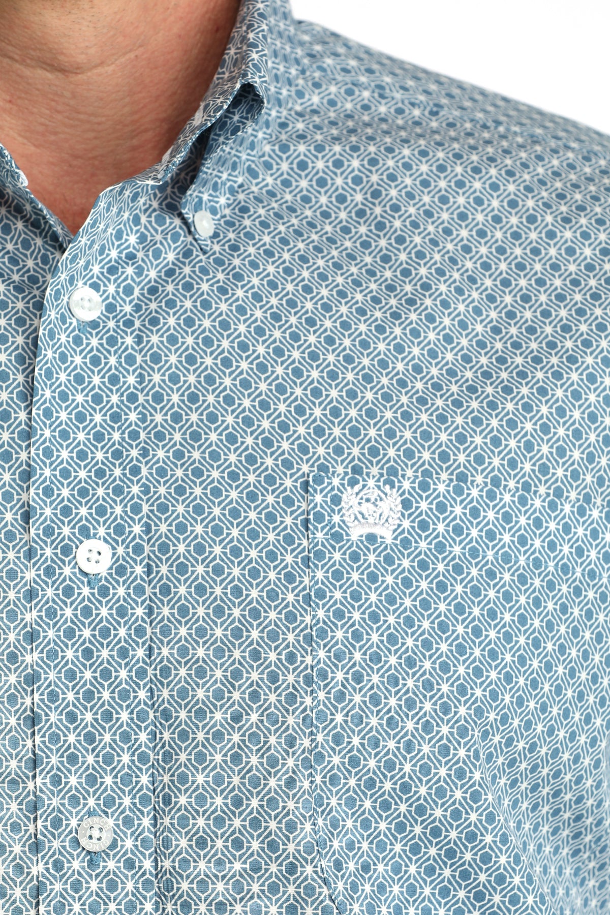 Close-up of a blue patterned shirt with white buttons on a white background