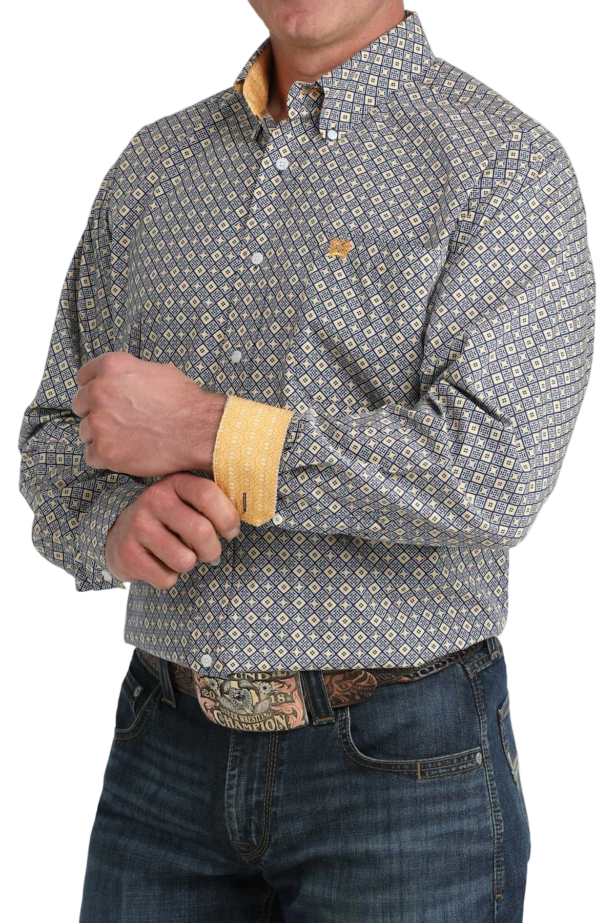 Man wearing a patterned shirt with rolled-up sleeves and jeans on a white background