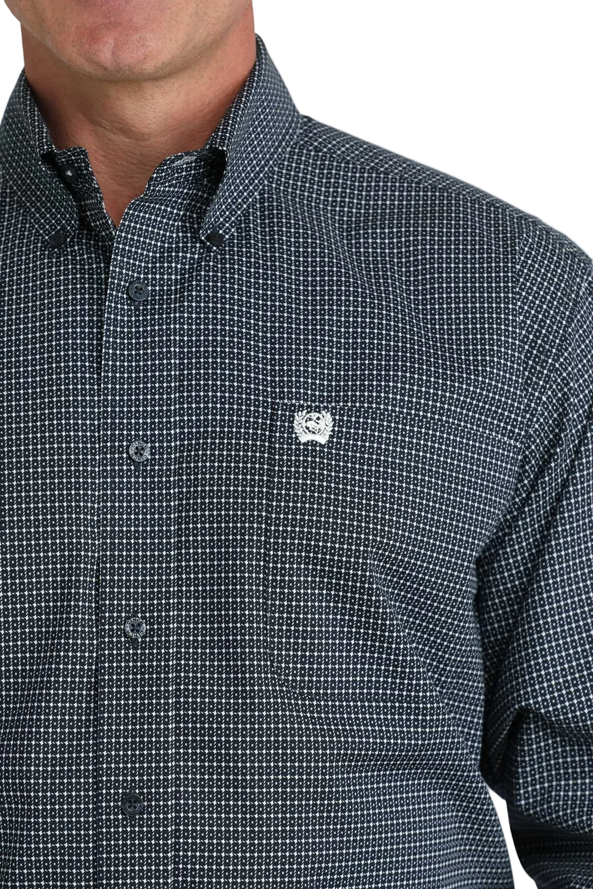 Close-up of a person wearing a black checkered shirt with a logo on a white background