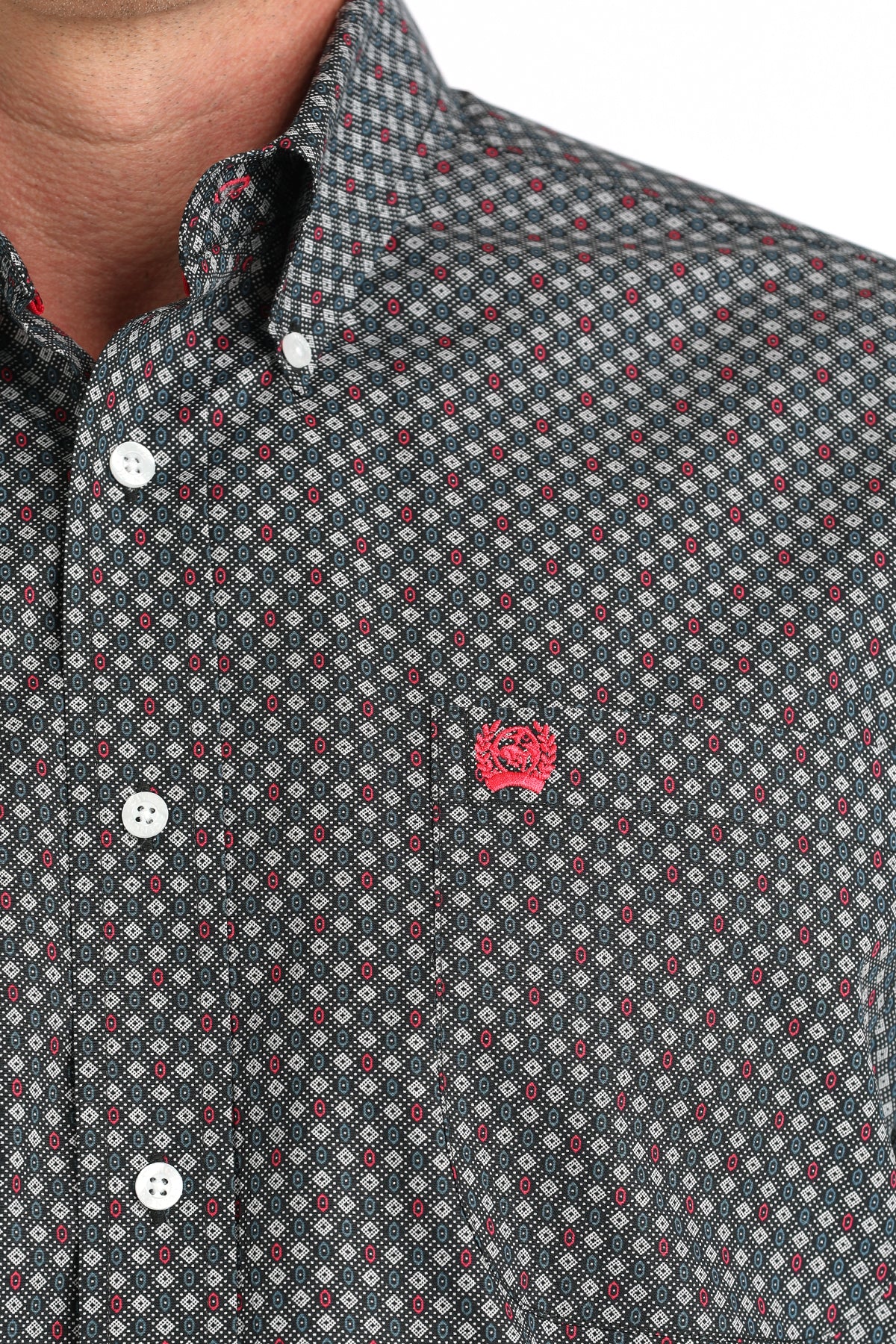 Close-up of a patterned shirt with a small logo on a white background
