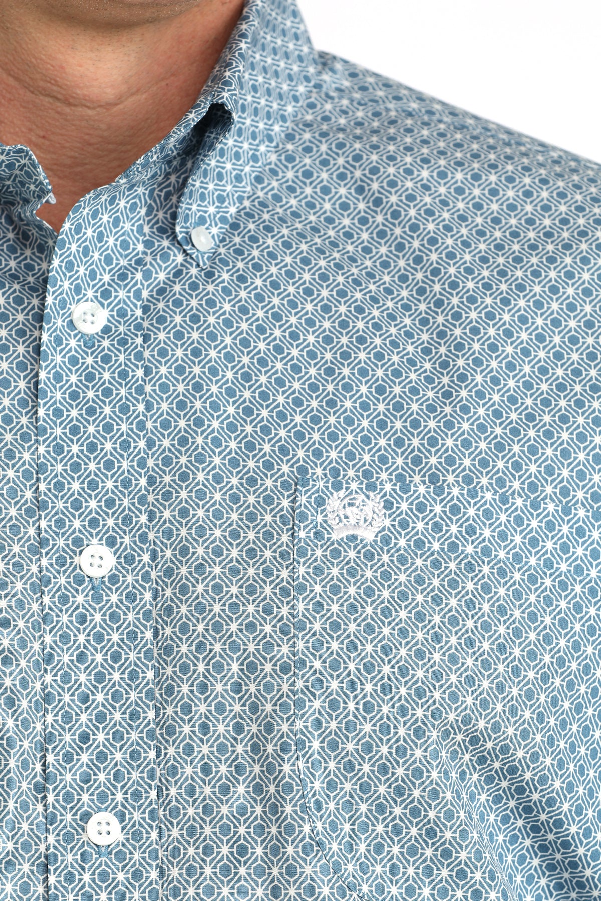 Close-up of a blue patterned shirt with white buttons on a white background