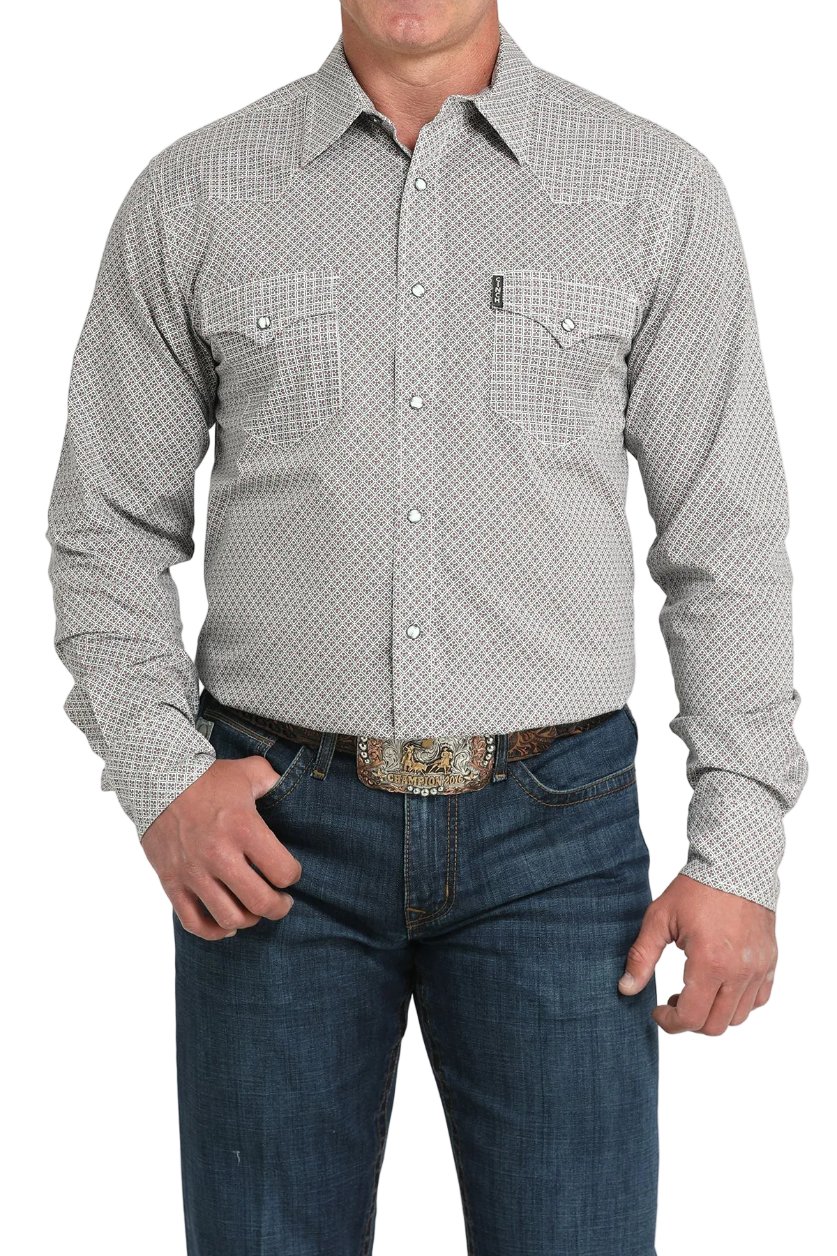 A man wearing a light gray patterned button-up shirt, dark jeans, and a large belt buckle, standing against a transparent background
