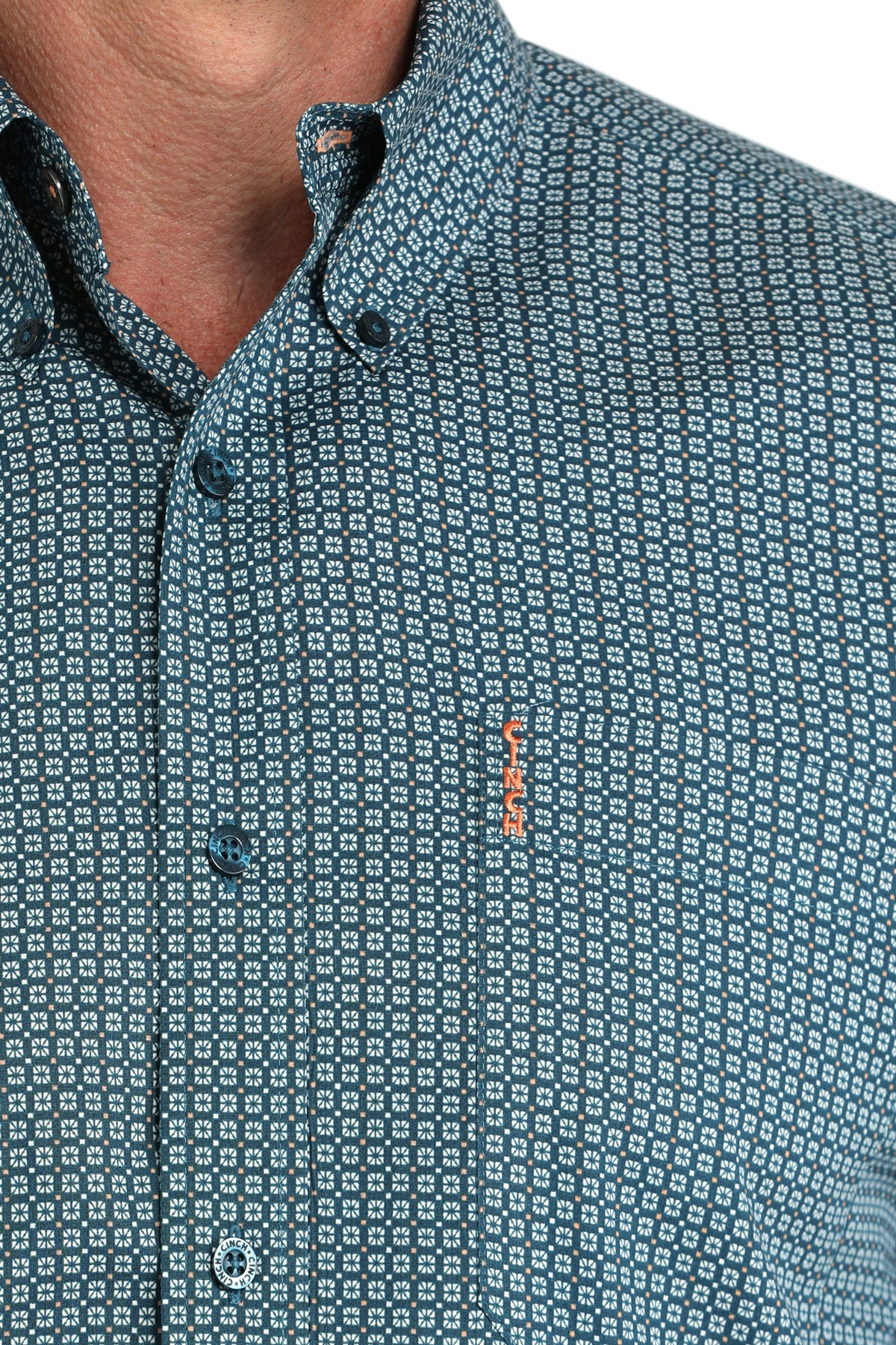Close-up of a man wearing a blue patterned button-up shirt on a white background