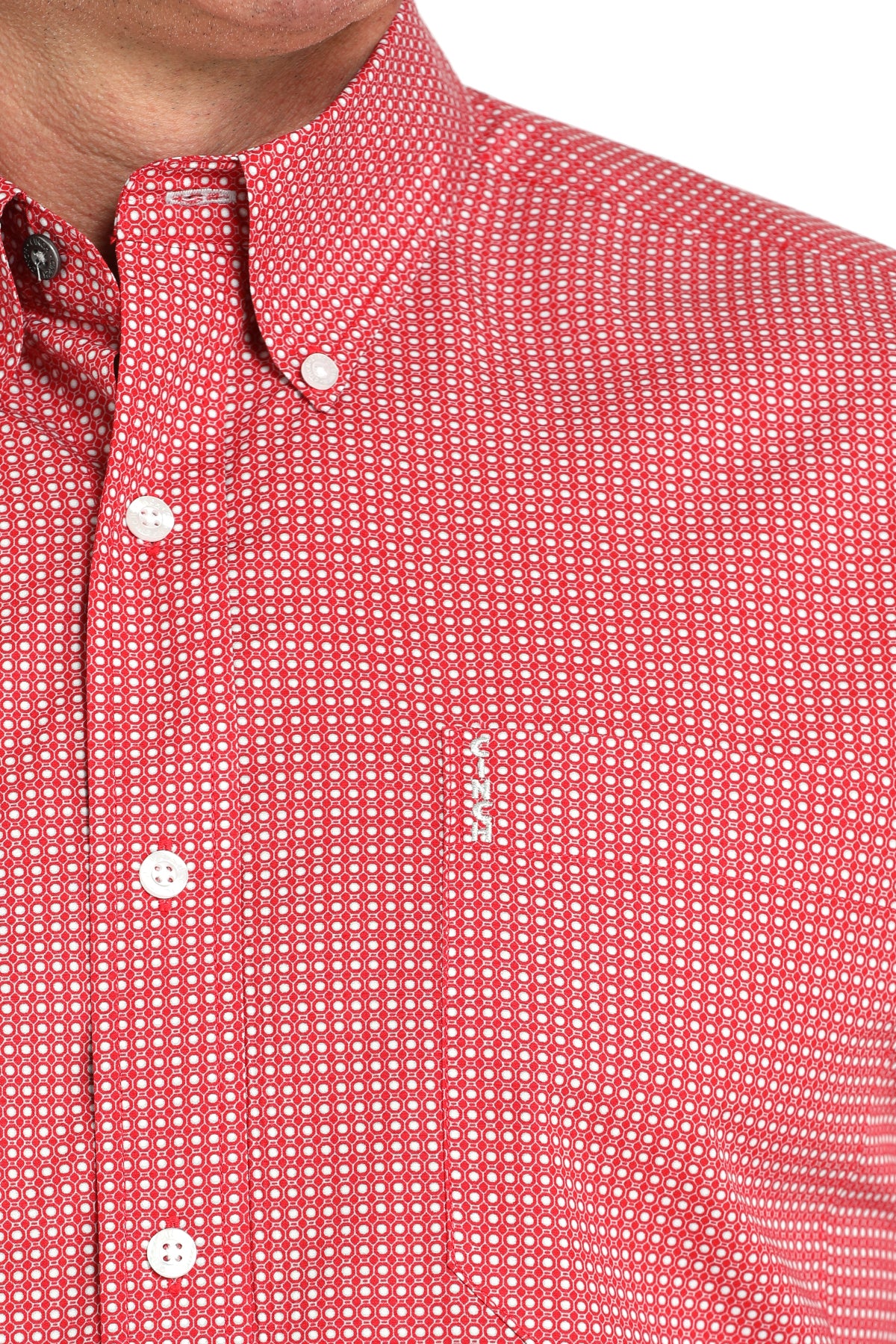Close-up of a man wearing a red patterned button-up shirt with a chest pocket, displayed against a white background