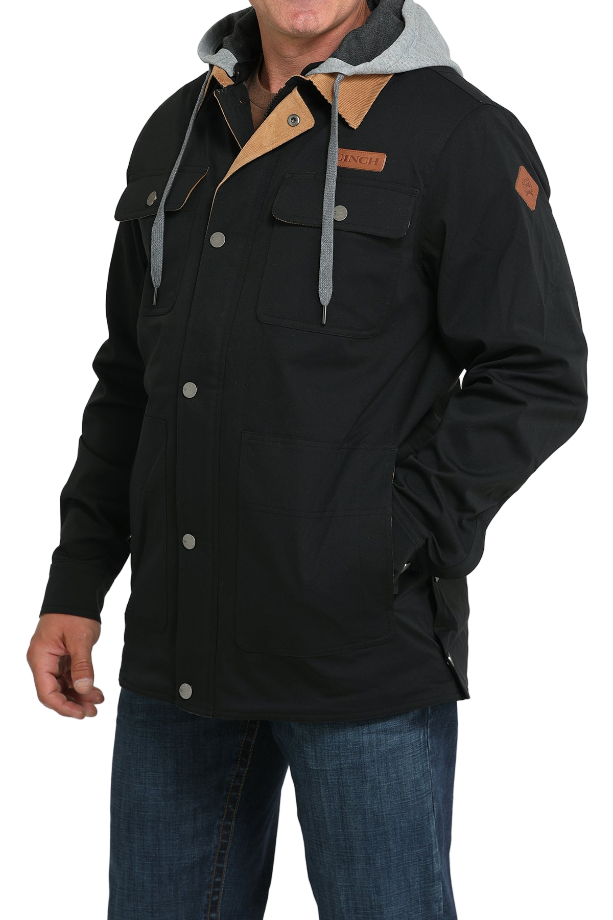 Man wearing a black jacket with a tan corduroy collar and blue jeans