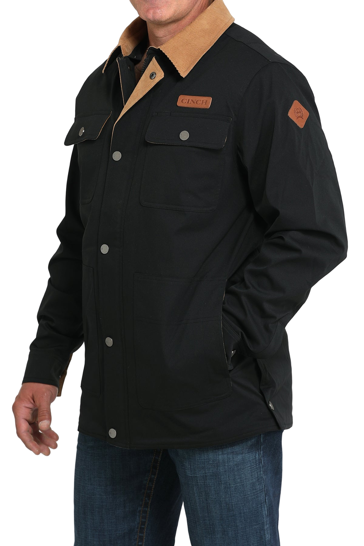 Man wearing a black jacket with a tan corduroy collar and blue jeans