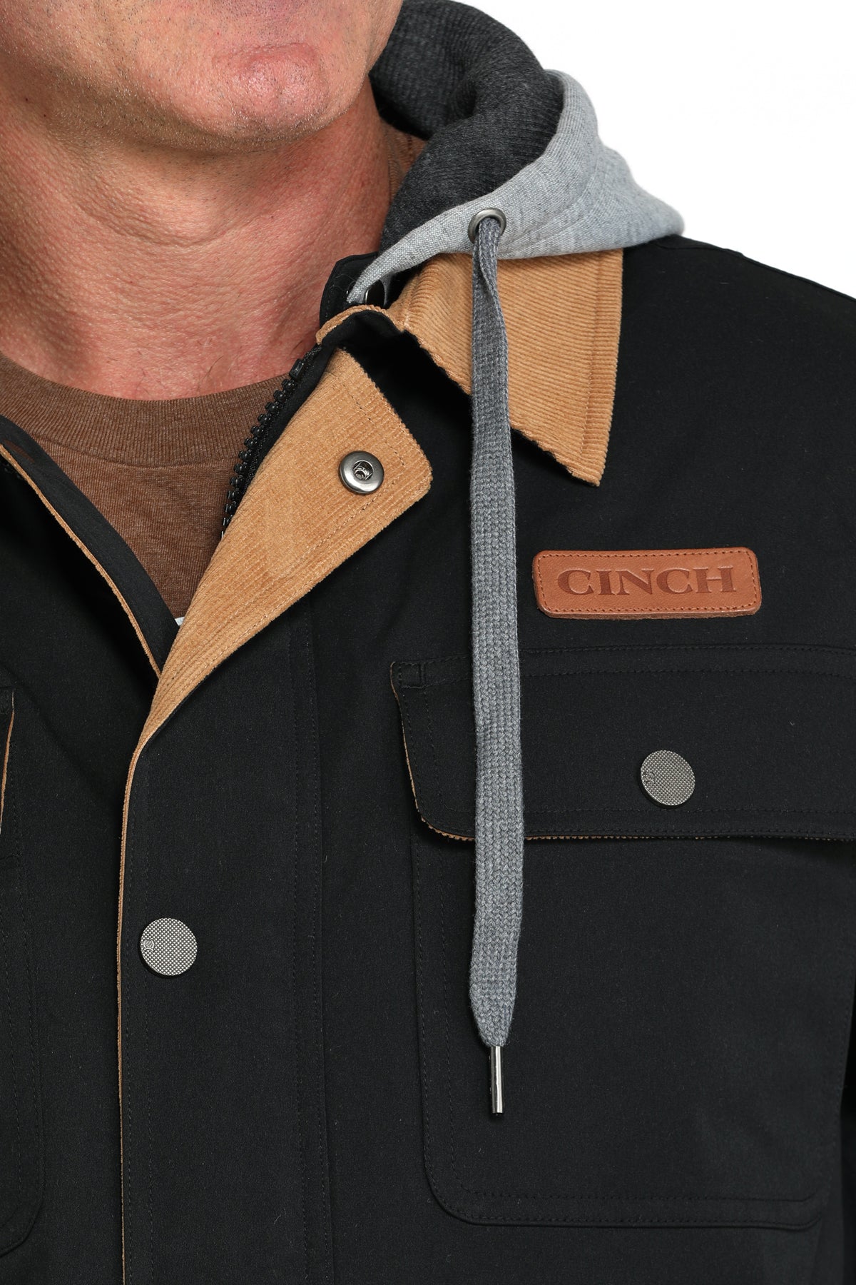 Close-up of a man wearing a black jacket with a 'CINCH' logo