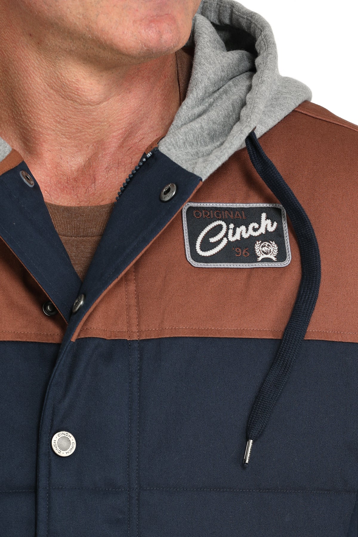 Close-up of a man wearing a multi-colored hoodie jacket with a 'CINCH' logo
