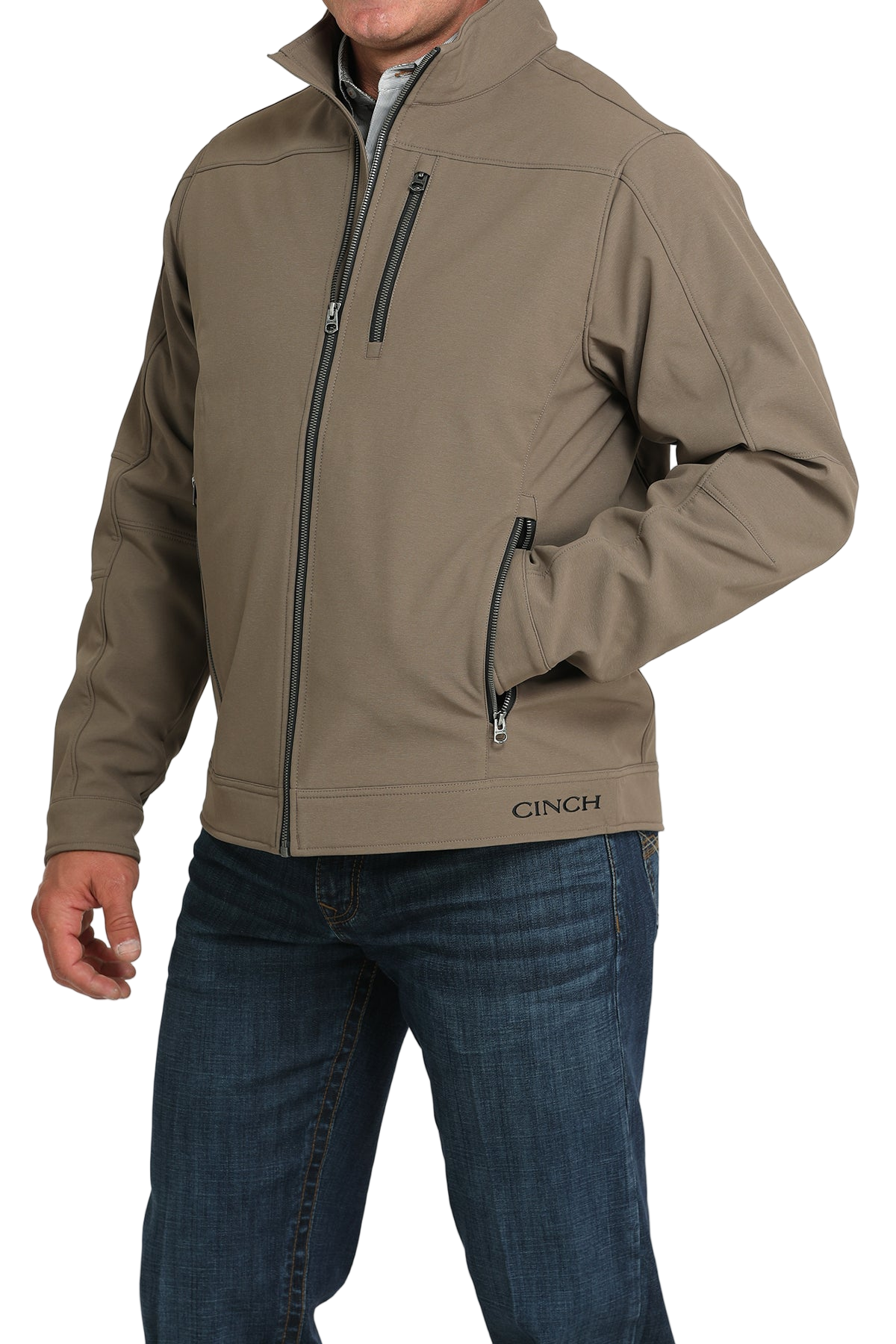 Man wearing a tan zip-front jacket, paired with dark jeans