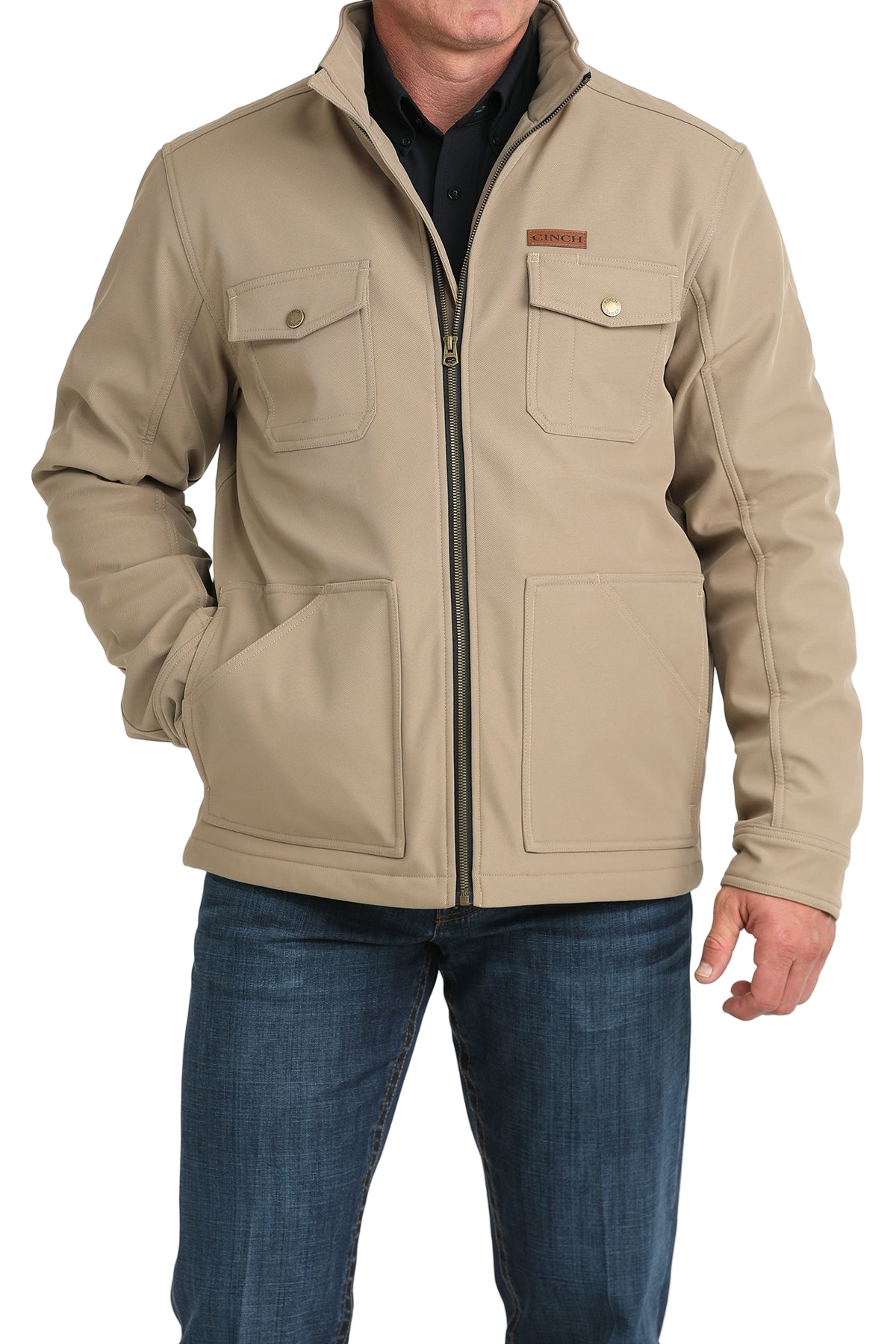 Man wearing a tan zip-front jacket with buttoned chest pockets, paired with dark jeans