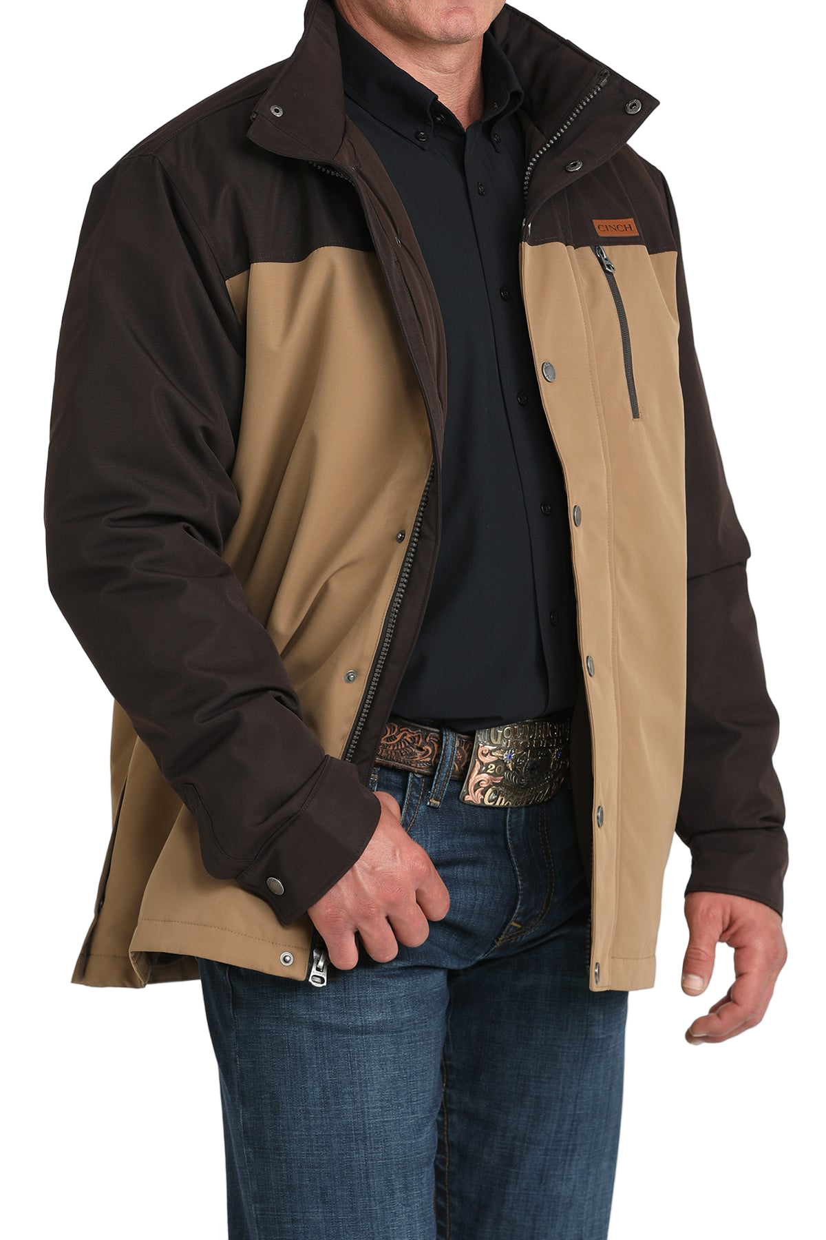 Man wearing a two-tone brown hooded jacket paired with blue jeans