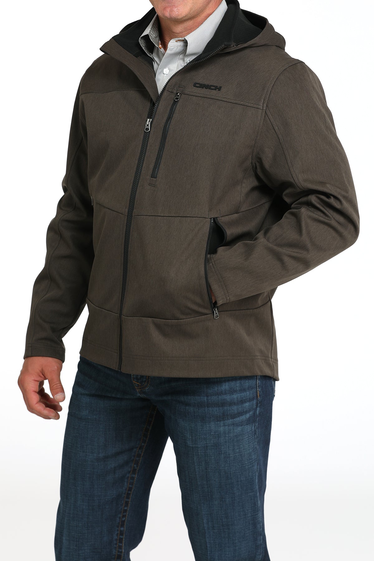 Man wearing a green jacket and jeans on a white background 