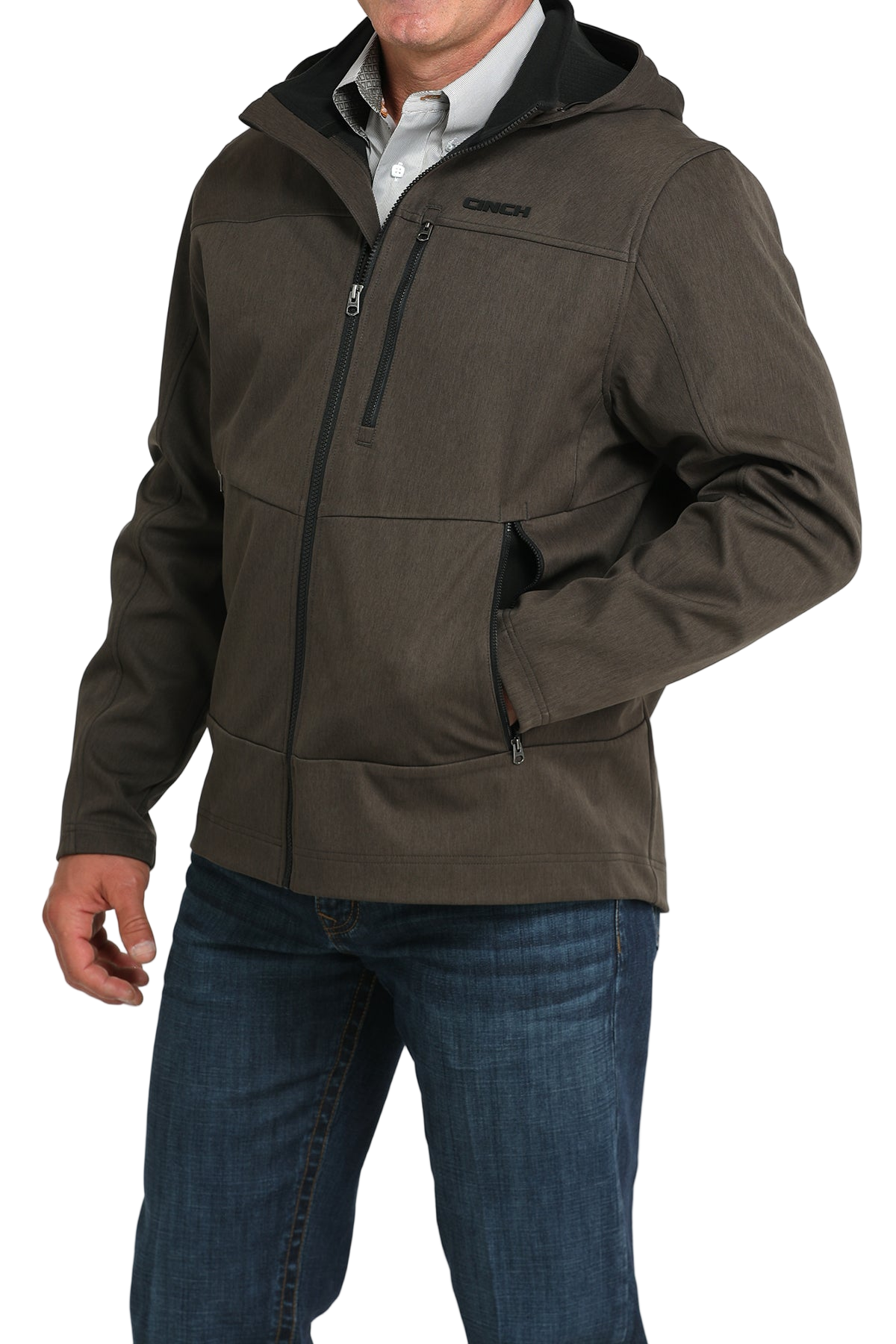 Man wearing a brown hooded softshell jacket paired with blue jeans