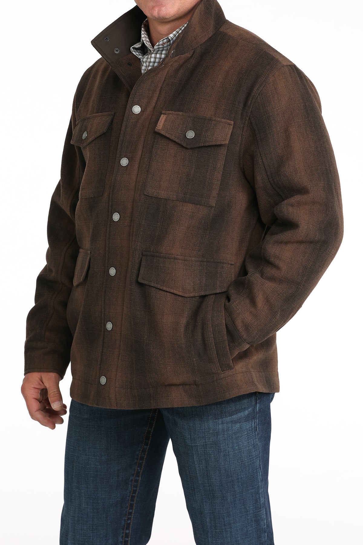 Man wearing a brown plaid jacket with buttons and pockets, paired with jeans