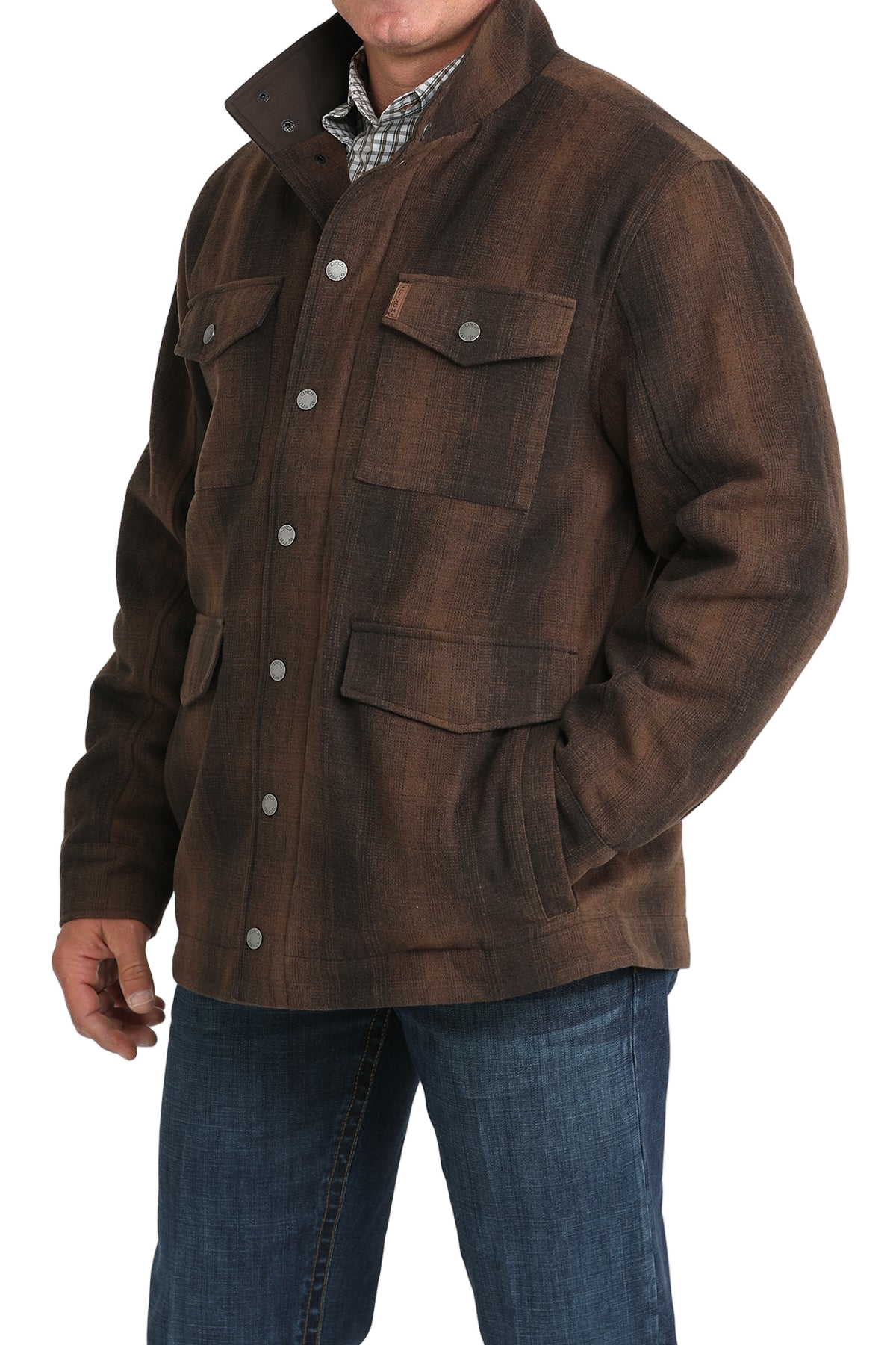 Man wearing a brown button-front jacket with multiple flap pockets, paired with blue jeans