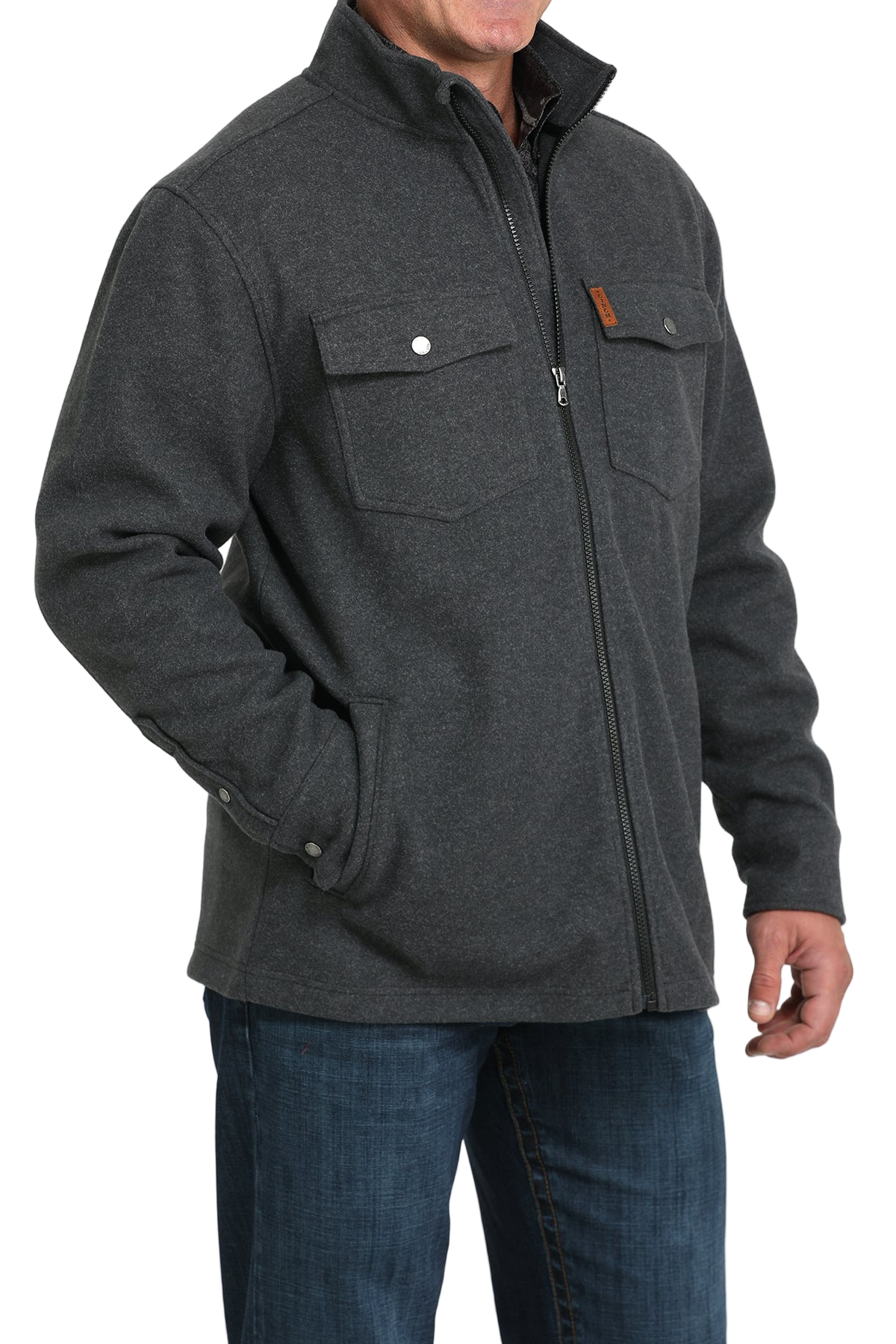 Man wearing a dark gray zip-front jacket with flap chest pockets, paired with blue jeans