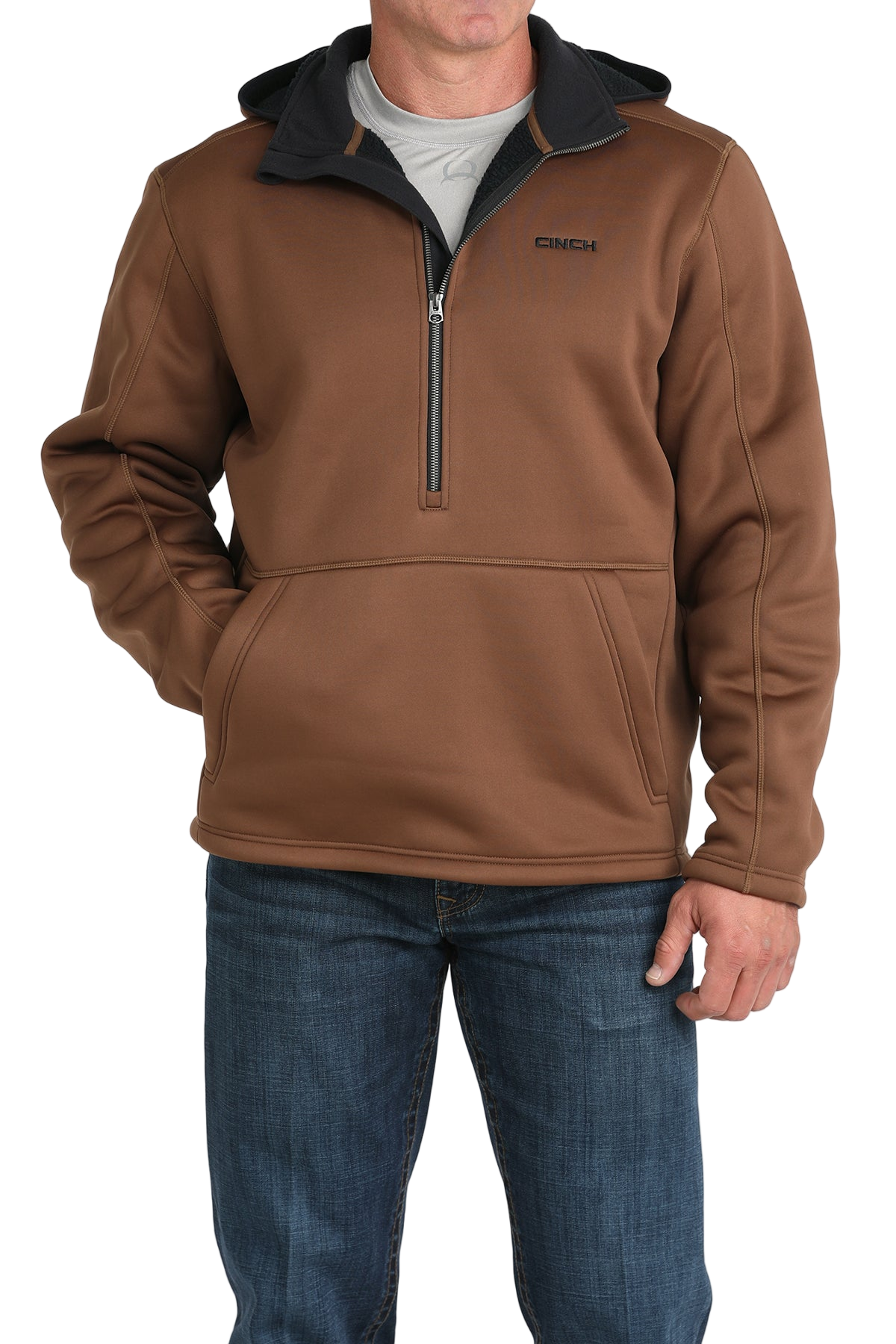 Man wearing a brown quarter-zip pullover with a black inner collar and a front kangaroo pocket, paired with blue jeans