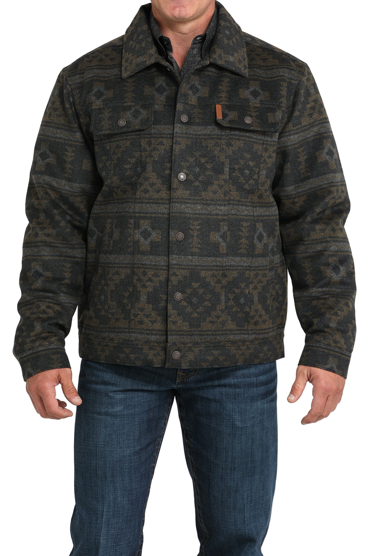 Man wearing a patterned dark green and black jacket with front buttons and chest pockets, paired with blue jeans