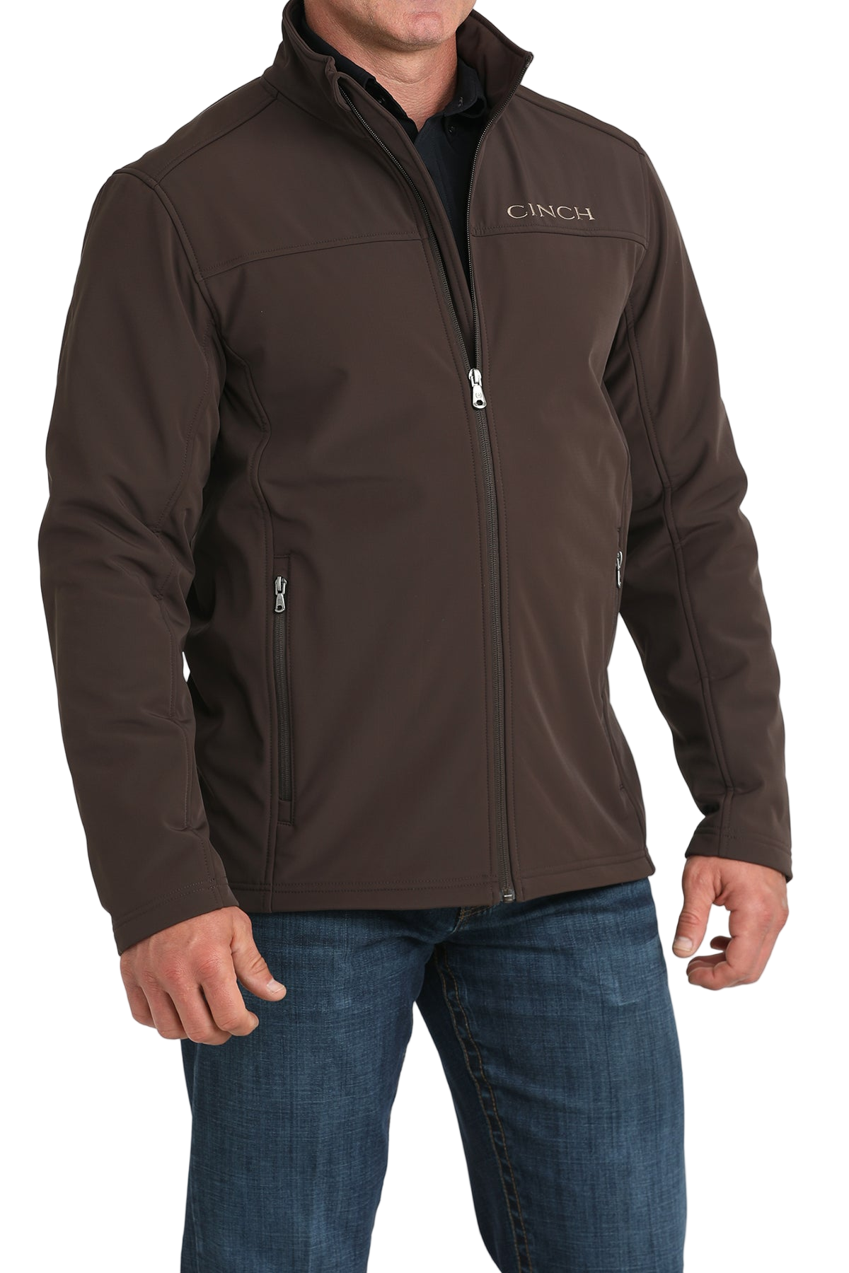 Man wearing a brown CINCH jacket with a full front zipper, paired with a black shirt and blue jeans