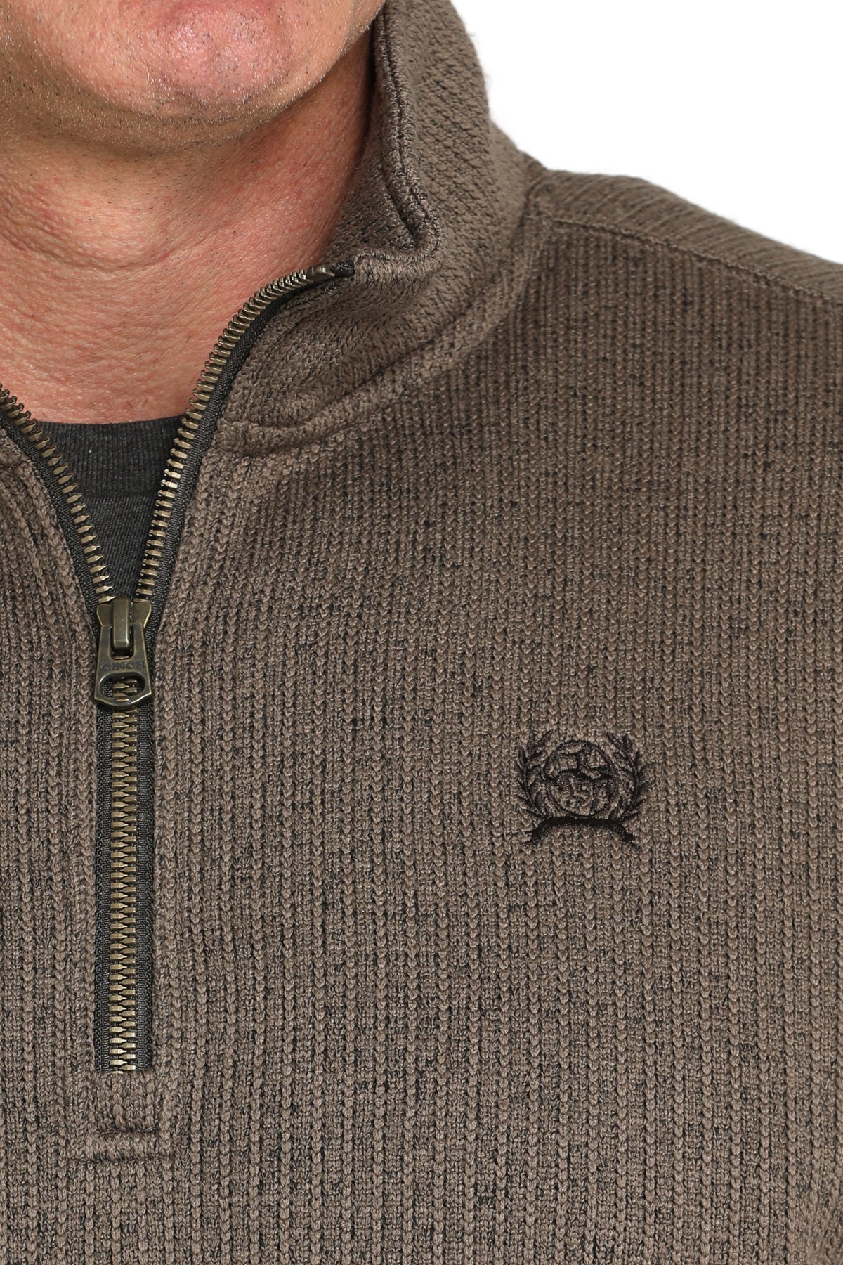 Close-up of a man wearing a brown 1/4 zip jacket with a small 'CINCH' emblem