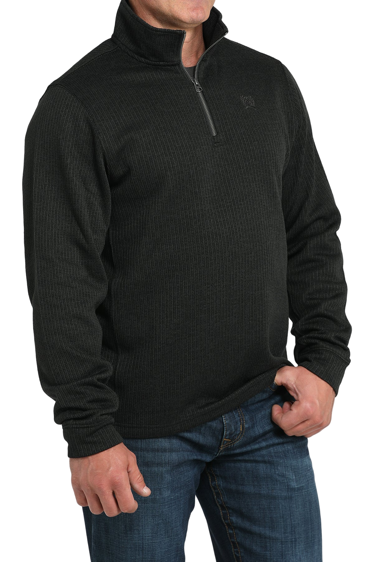 Person wearing a black quarter-zip pullover and blue jeans on a white background