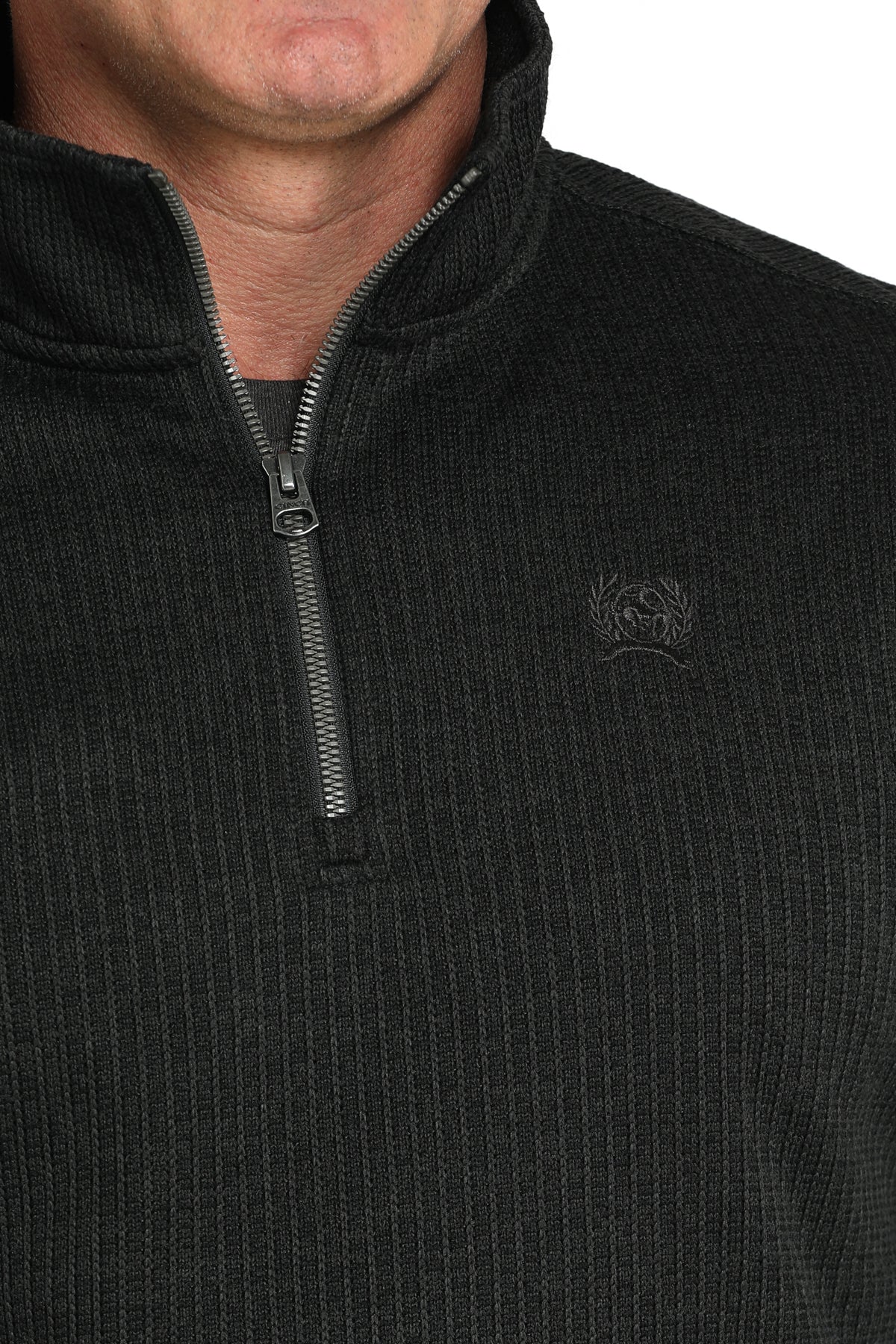 Close-up of a man wearing a black 1/4 zip jacket with a small 'CINCH' emblem