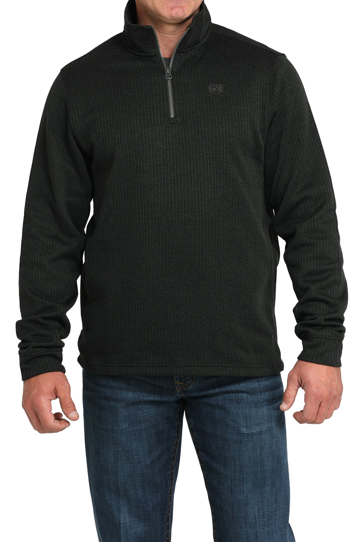 Man wearing a black quarter-zip sweater and blue jeans on a white background