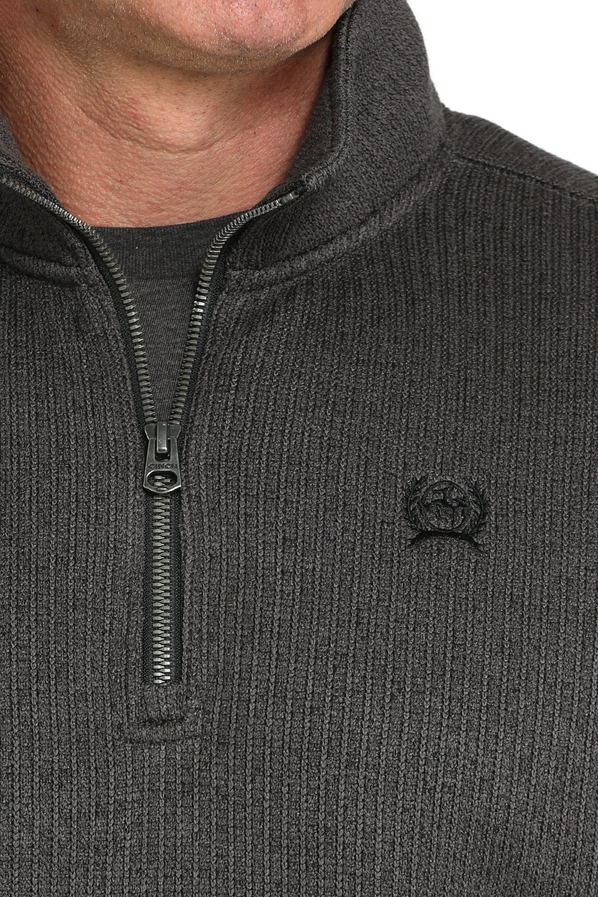 Close-up of a man wearing a gray 1/4 zip jacket with a small 'CINCH' emblem