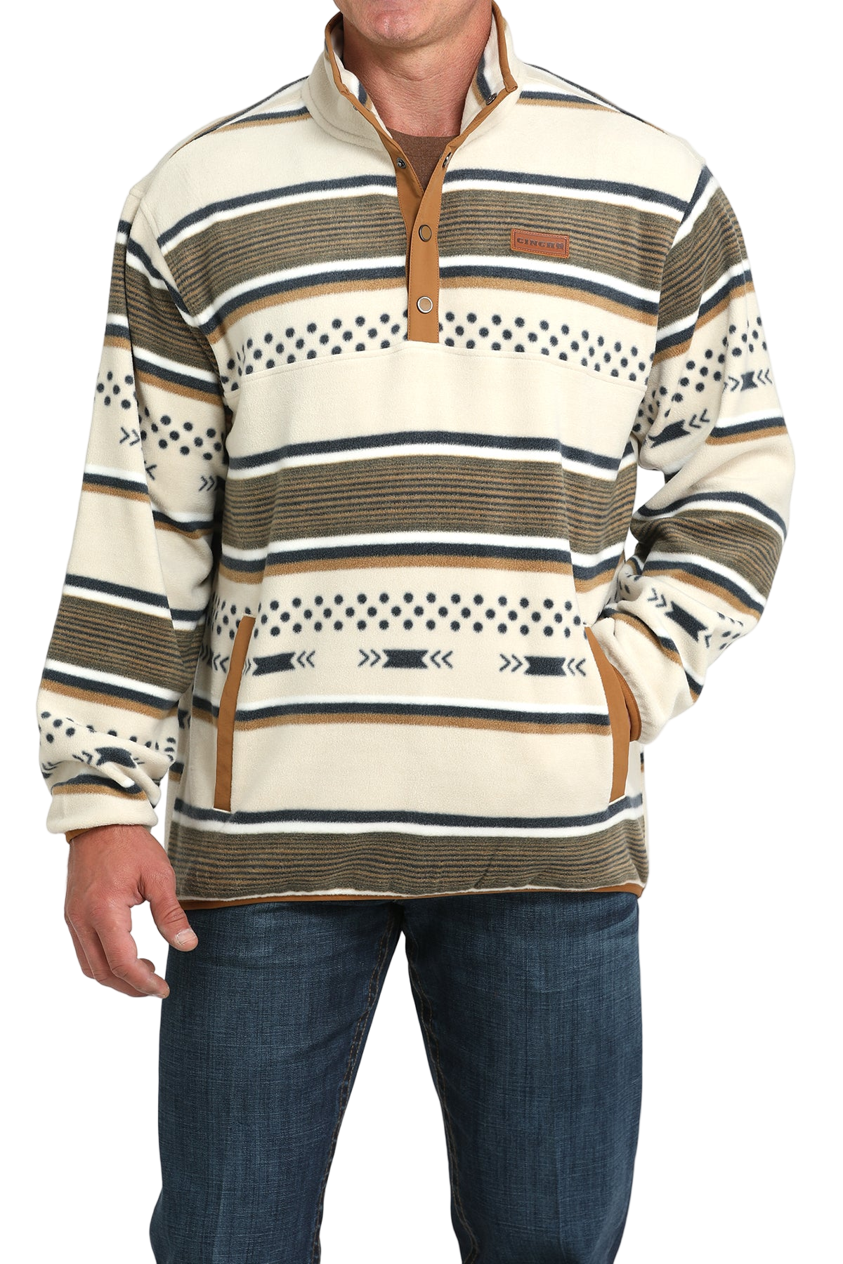 Man wearing a cream and tan striped pullover with a buttoned placket and side pockets, paired with blue jeans