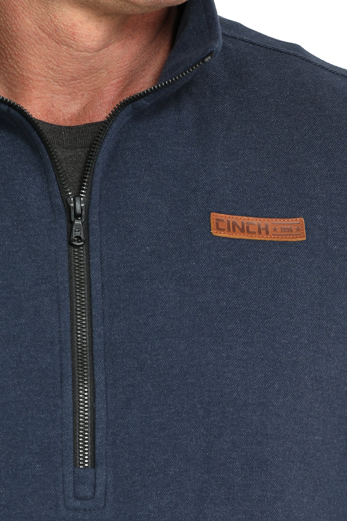 Close-up of a man wearing a blue 1/2 zip jacket with a 'CINCH' logo