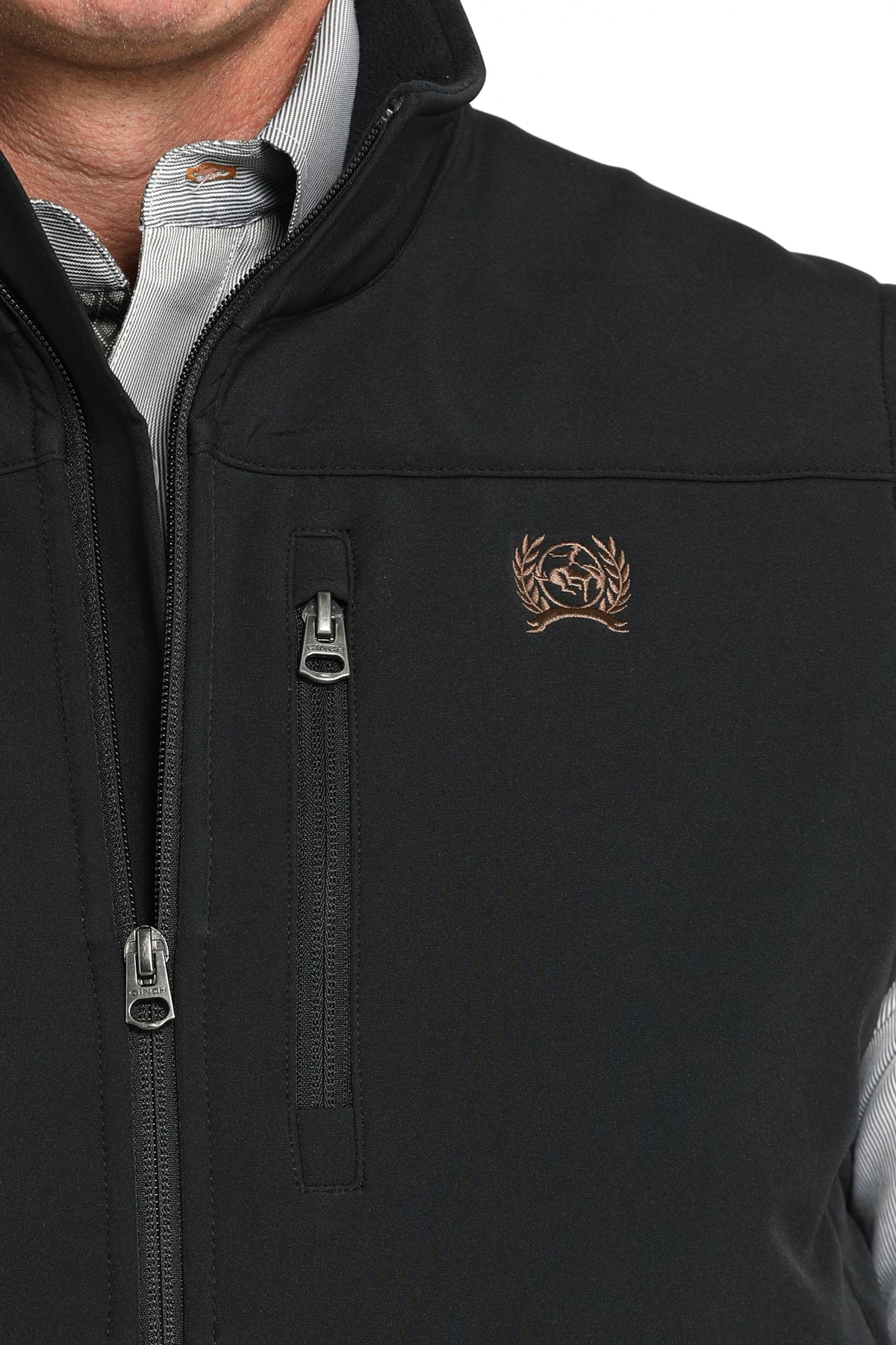 Close-up of a man wearing a black vest with a cinch logo 
