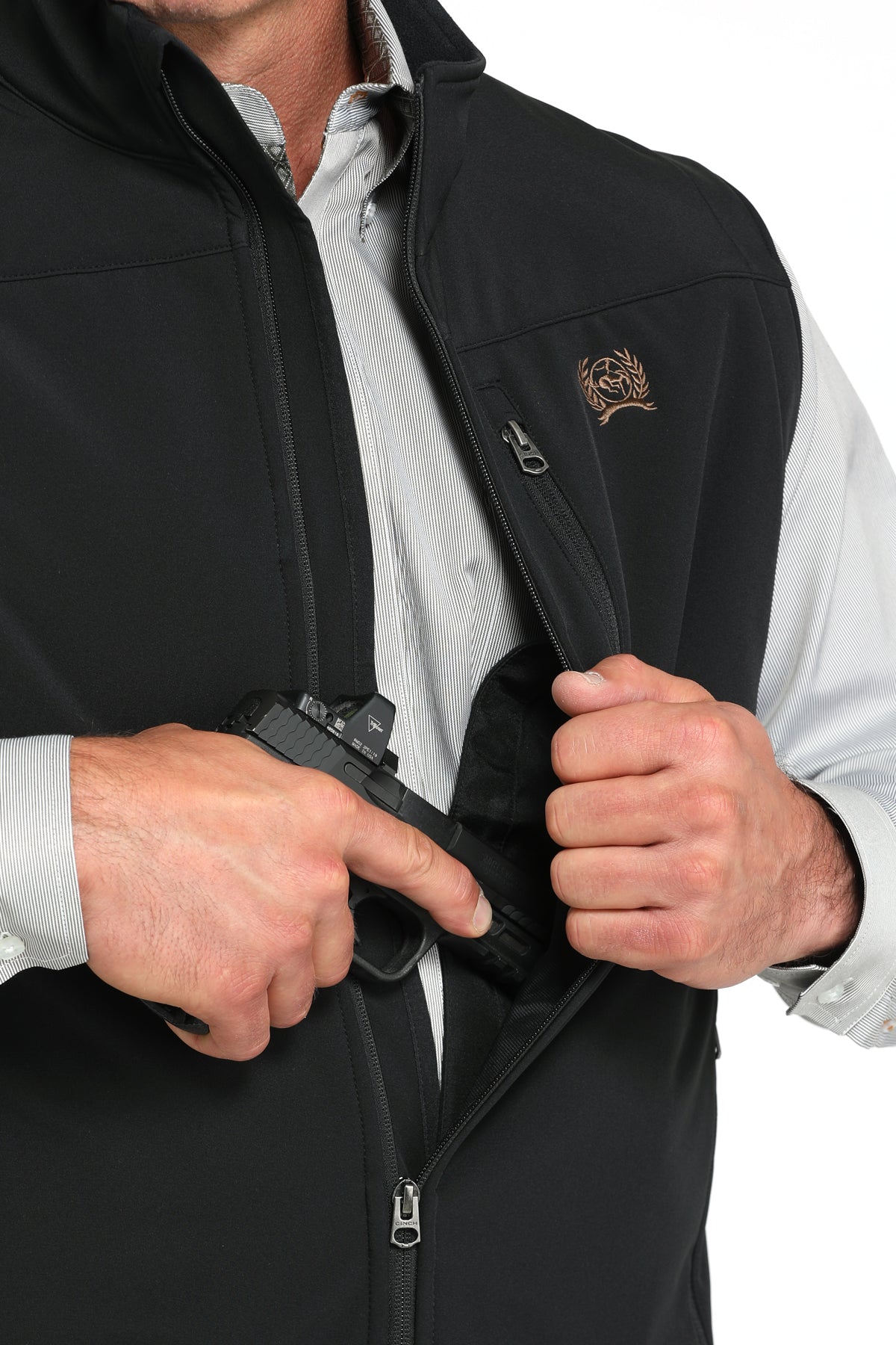 Man wearing a black vest with a long sleeve button-down undershirt, partially showing a firearm going into the concealed carry pocket