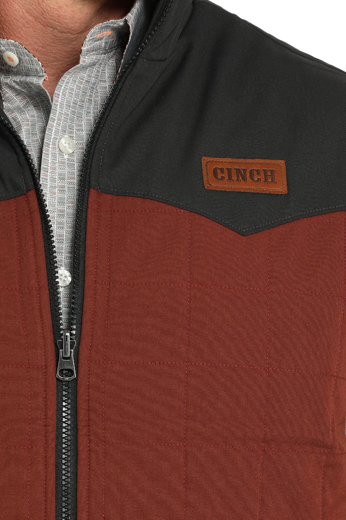 Close-up of a man wearing a vest with an undershirt