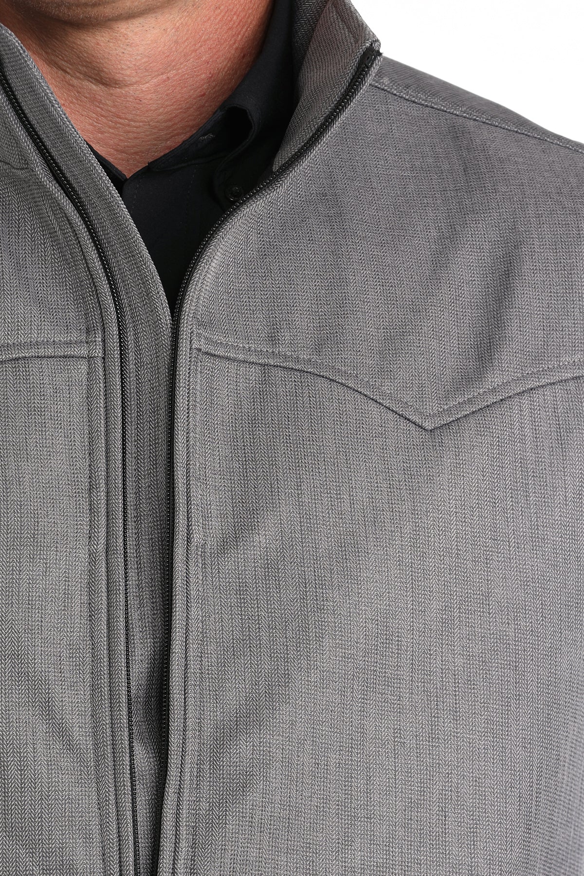 Close-up of a man wearing a gray vest with a back undershirt 