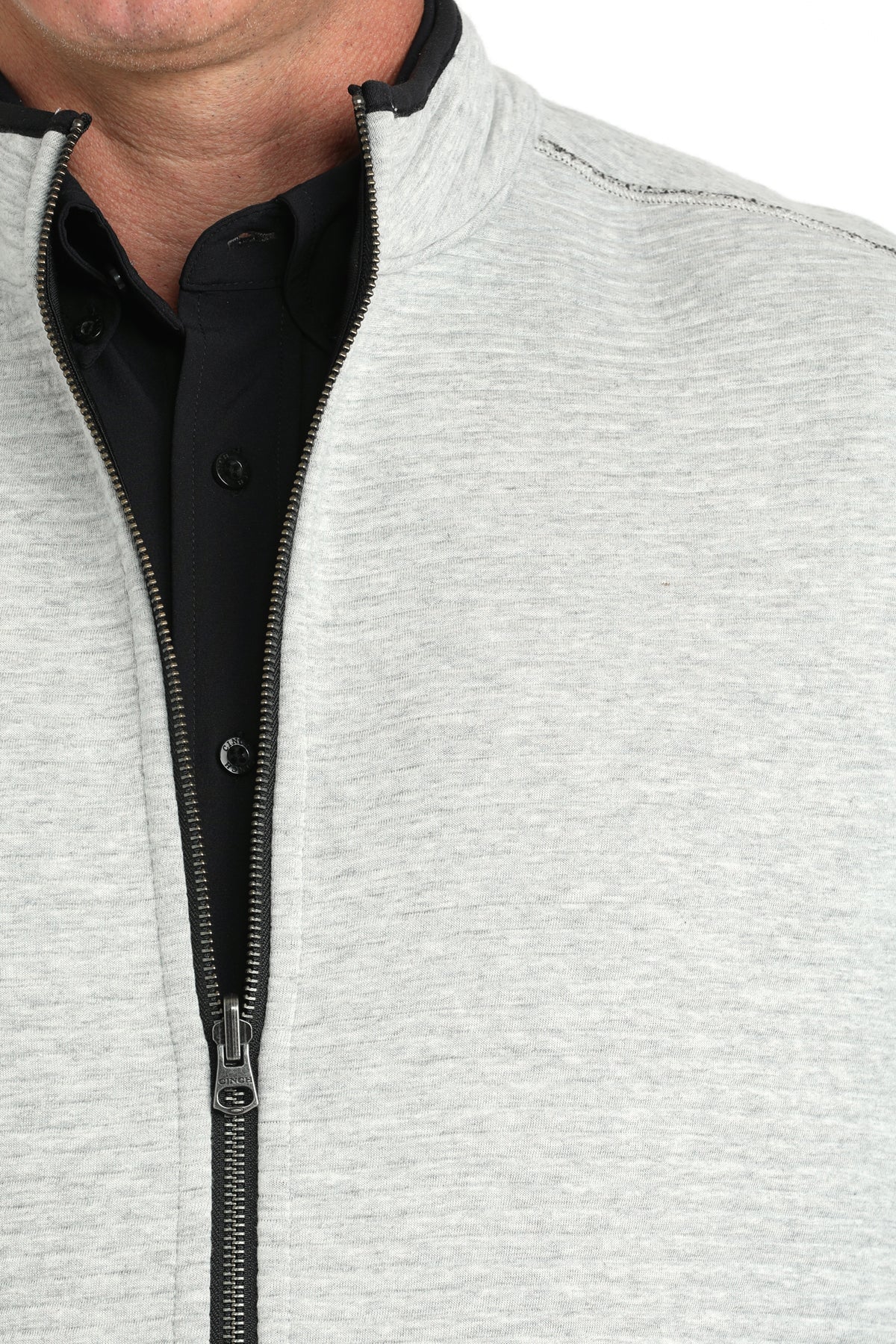 Close-up of a man wearing a white vest with a black undershirt 