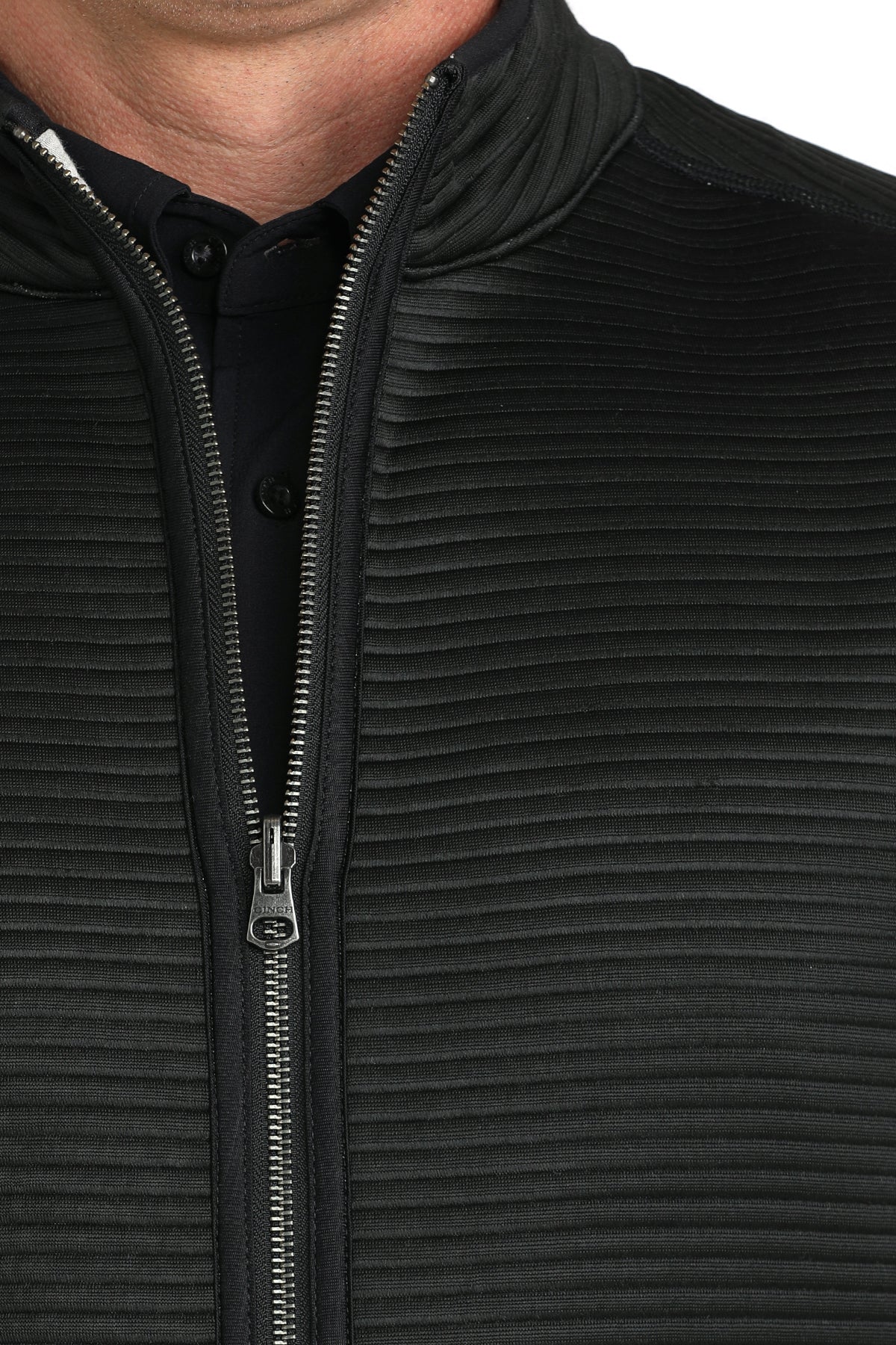 Close-up of a man wearing a black vest with a black undershirt