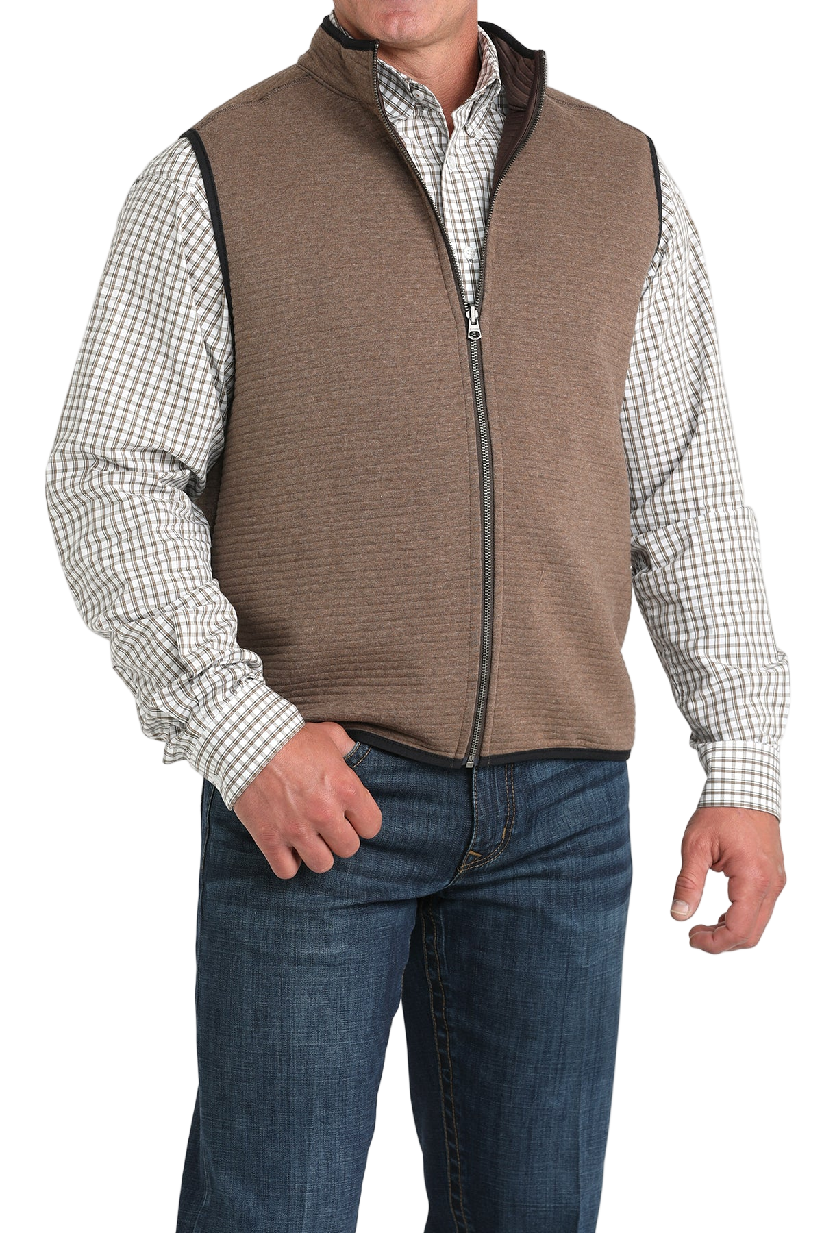 A man wearing a brown zip-up vest over a white and brown checkered button-down shirt, paired with blue jeans