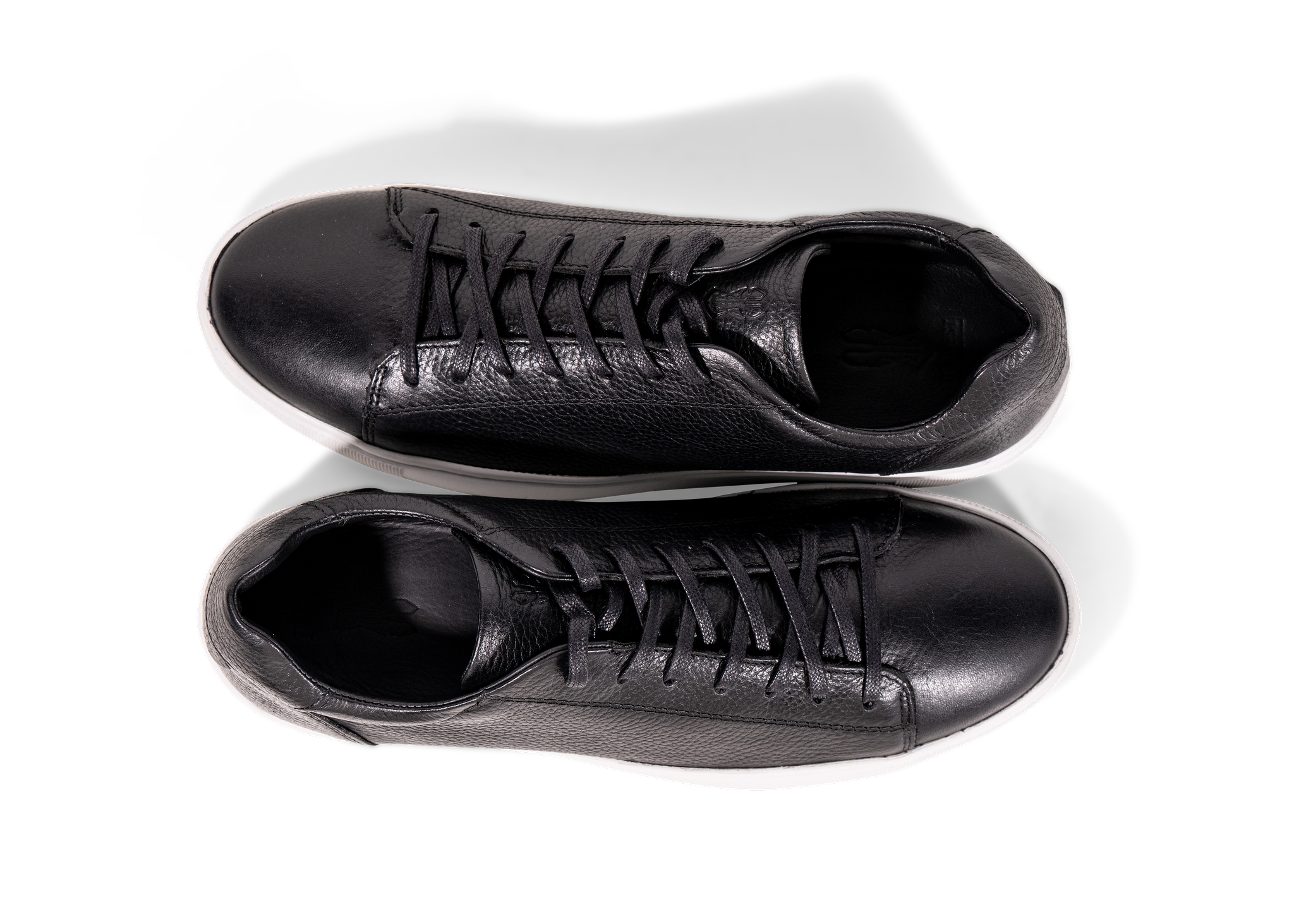 Pair of Go West Supply black leather sneakers with a white sole on a white background