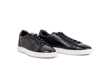 Pair of Go West Supply black leather sneakers with a white sole on a white background