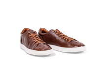 Pair of Go West Supply cognac ostrich leather sneakers on a white background