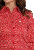 Close-up of a woman wearing a bright red long-sleeve button-down shirt with an allover geometric print