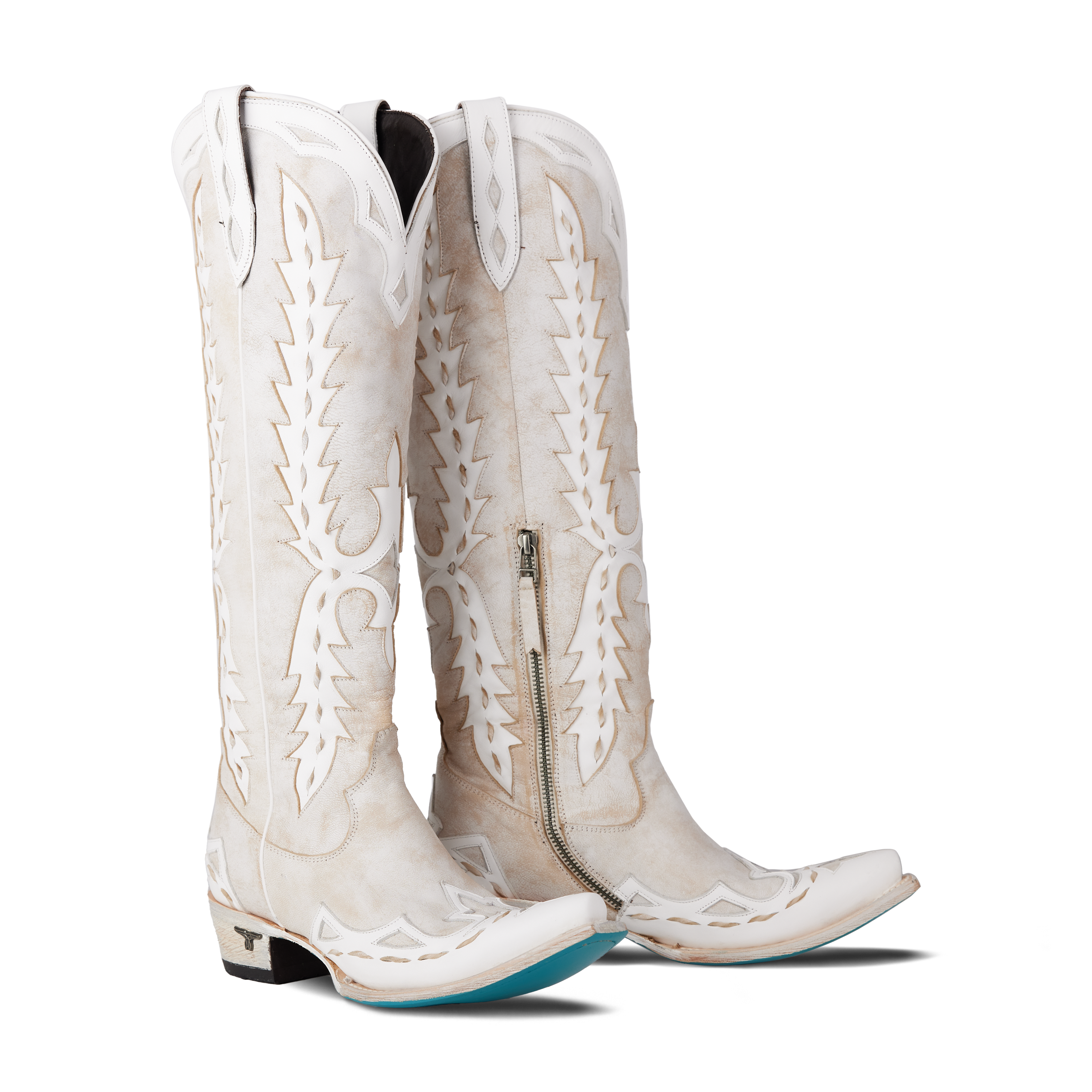 Pair of women’s white knee-high western boots with white stitching and cutout detailing, displayed on a white background