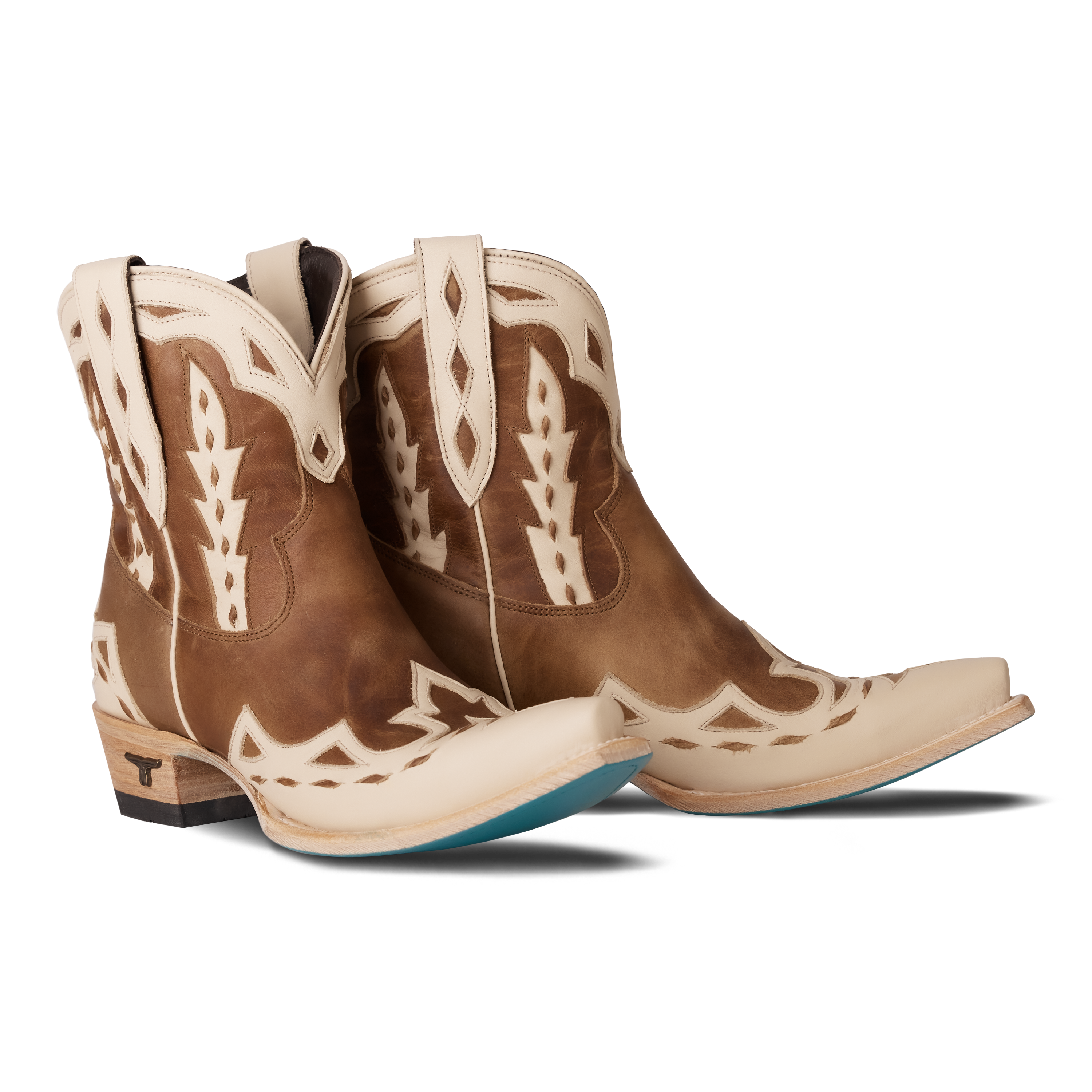 Pair of brown and cream western ankle boots featuring detailed stitching, a short shaft with pull tabs, and contrasting cream overlays 